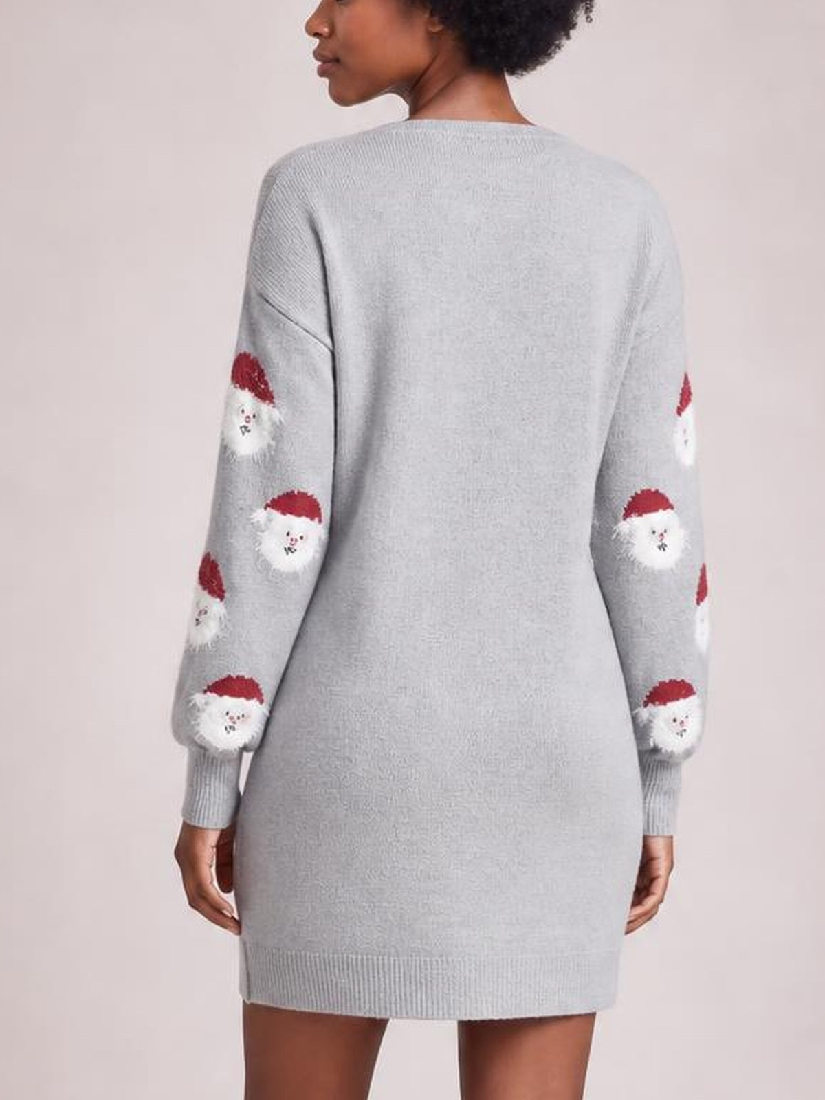 Back view of a light gray round neck dropped shoulder sweater dress with a relaxed silhouette, long sleeves, ribbed cuffs and hem, and Santa face motifs.