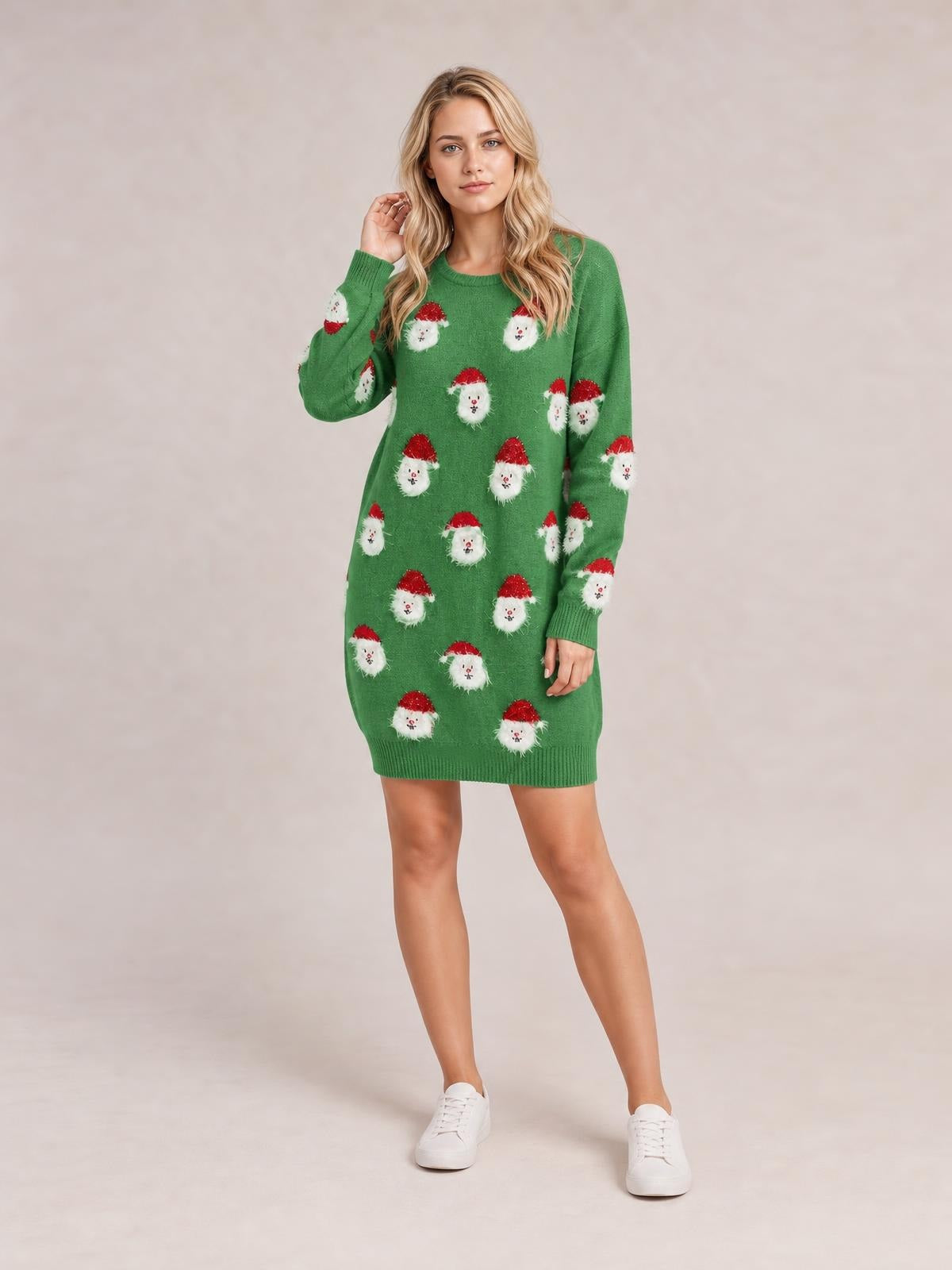 A model poses in a green round-neck dropped-shoulder sweater dress with long sleeves, Santa face motifs, and ribbed cuffs and hem in a relaxed above-knee silhouette.