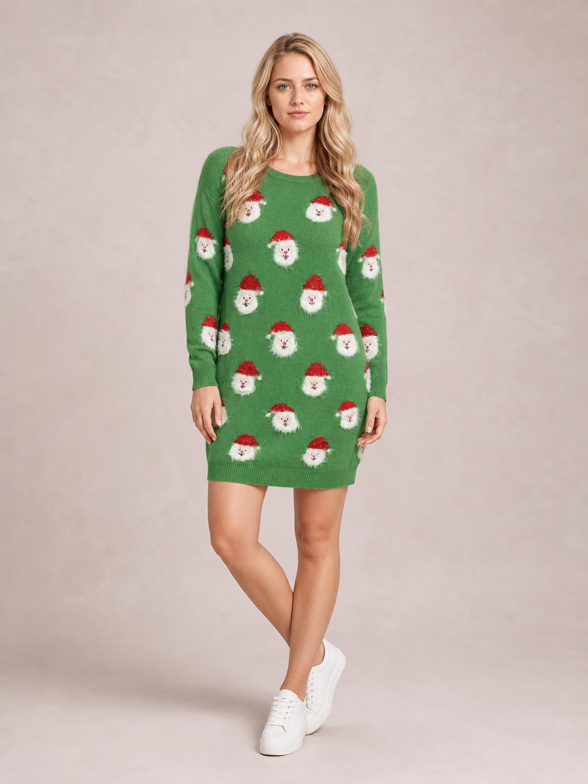 A model poses with crossed legs in a green round-neck dropped-shoulder sweater dress with long sleeves, Santa face pattern, ribbed cuffs, and a straight silhouette.