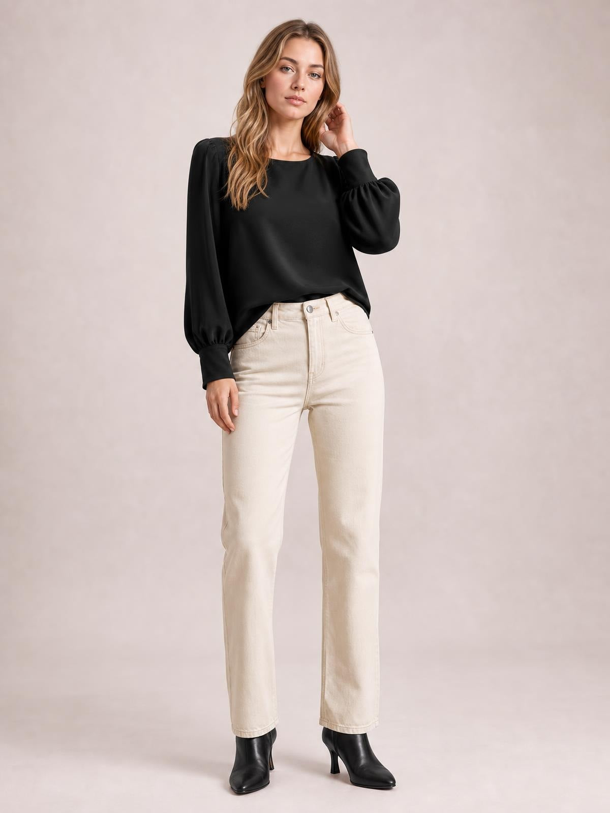 Model wearing a black round neck blouse with voluminous lantern sleeves, gathered cuffs, and a relaxed straight silhouette, paired with cream straight-leg jeans.