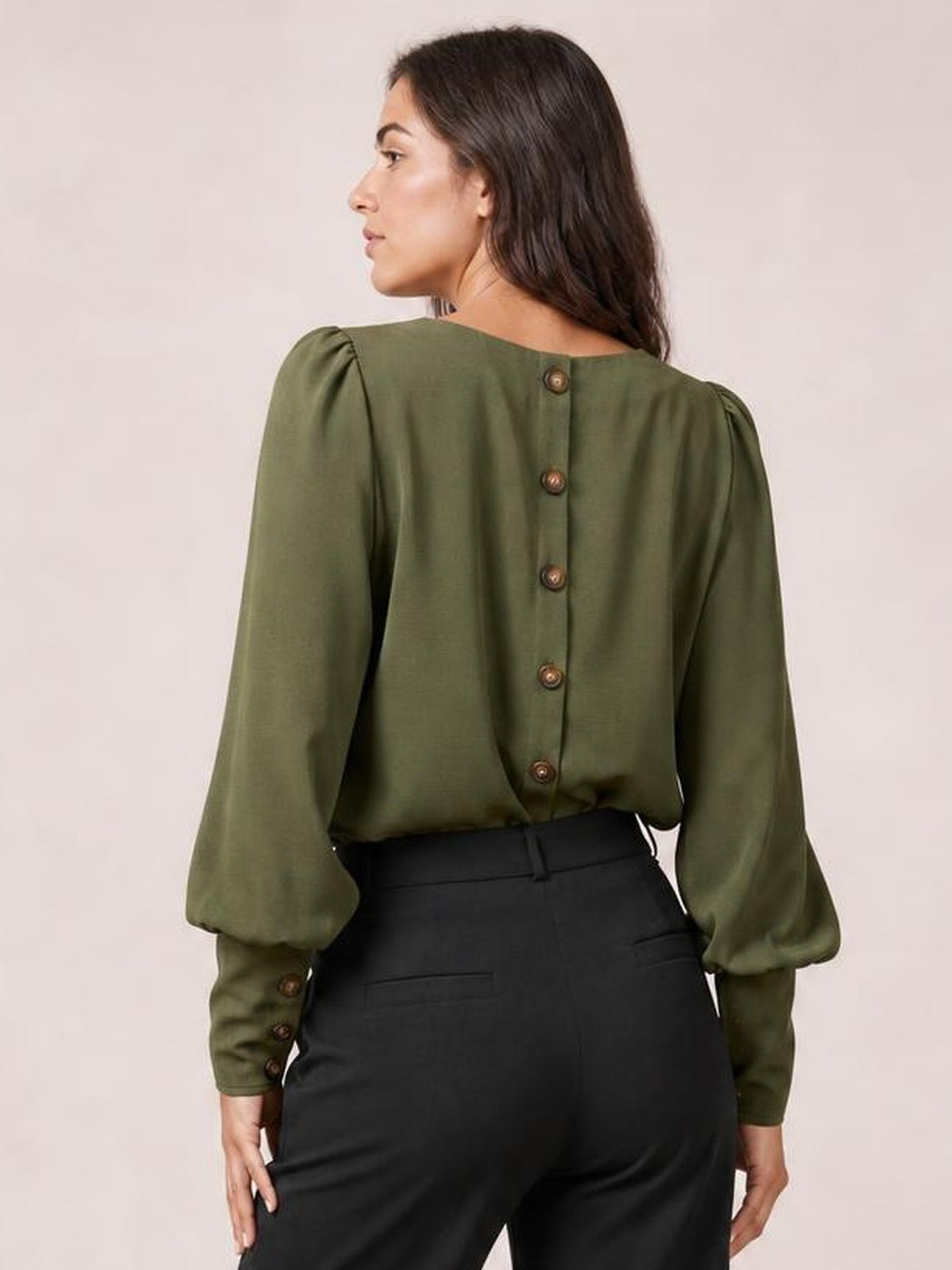 Model shown from the back wearing an olive green round neck blouse with lantern sleeves, button-back construction, gathered cuffs, and a relaxed silhouette.