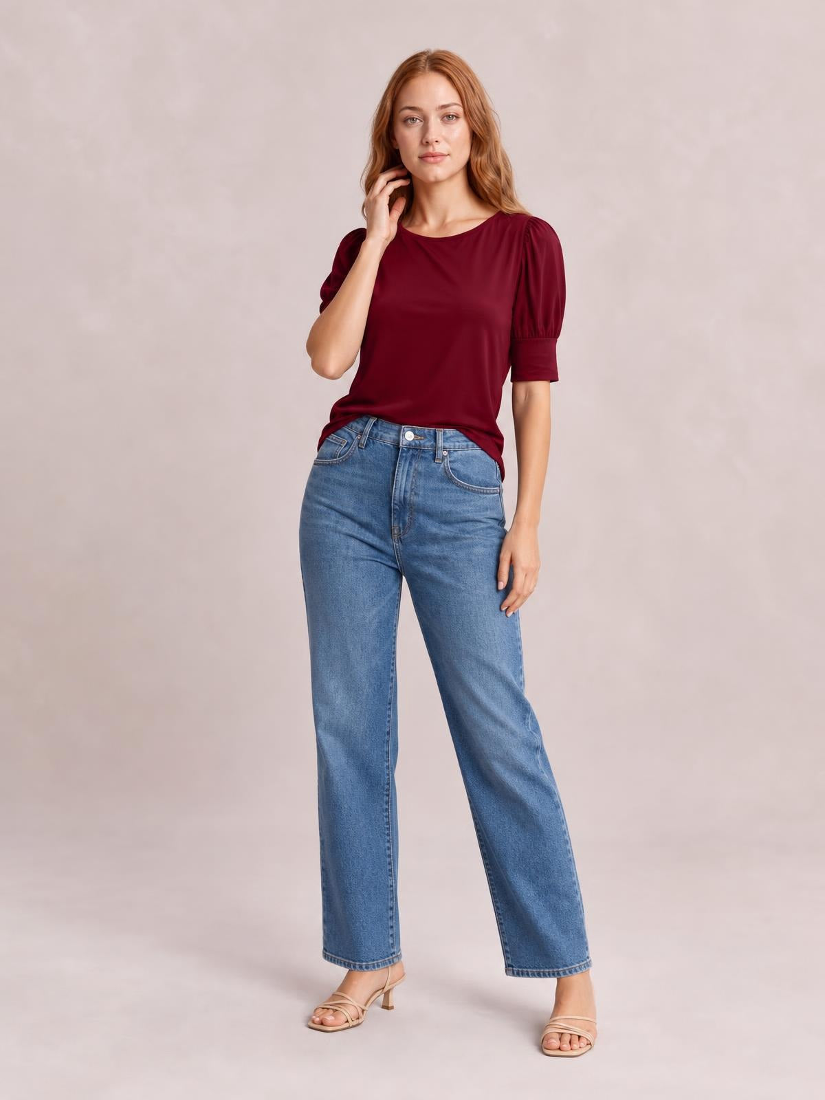Model wears a burgundy round neck lantern sleeve blouse with gathered elbow-length sleeves and cuffs, a relaxed straight silhouette, and a hand-to-neck pose.
