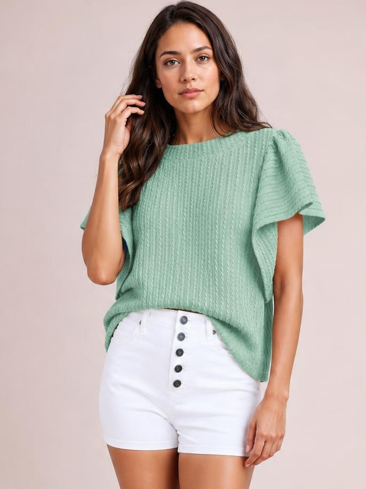A model poses in a mint green round neck top with textured vertical detailing, ruffled short sleeves, and a relaxed straight silhouette.