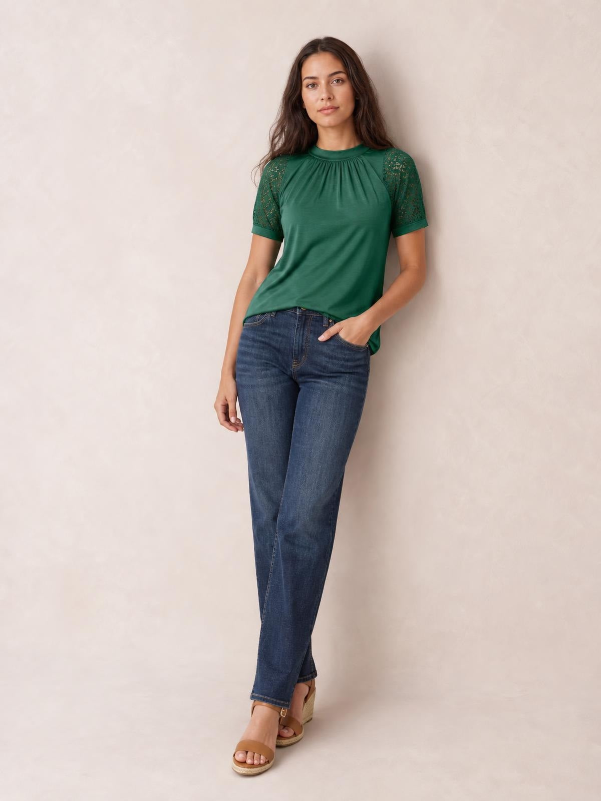 Model wears a green round neck short sleeve T-shirt with lace-detail sleeves, gathered neckline, and a relaxed straight silhouette, posing with one hand in her pocket.
