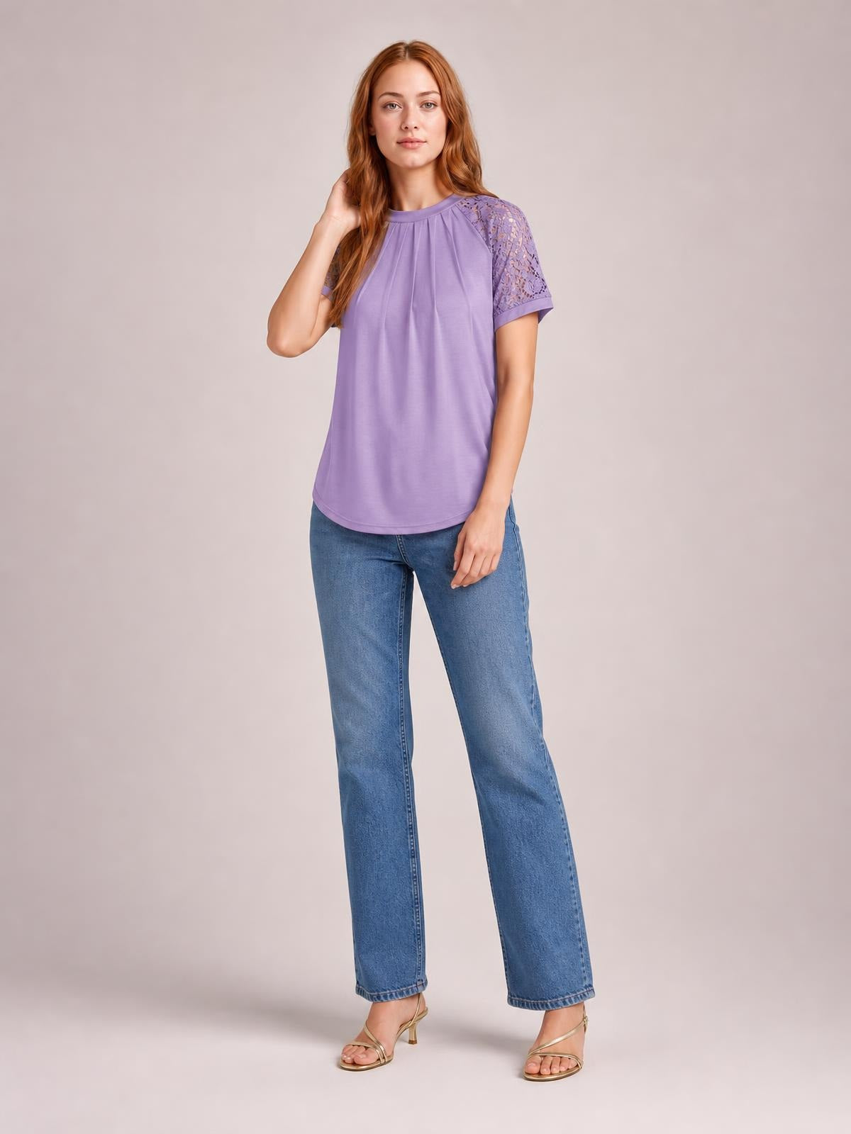 Model poses with one hand in her hair wearing a lavender round neck short sleeve T-shirt with lace sleeve details and a relaxed, curved hem.