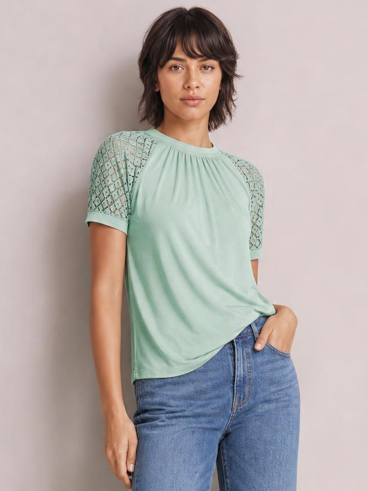 Model poses in a mint green round neck short sleeve T-shirt with gathered detailing, lace sleeves, and a relaxed straight silhouette.