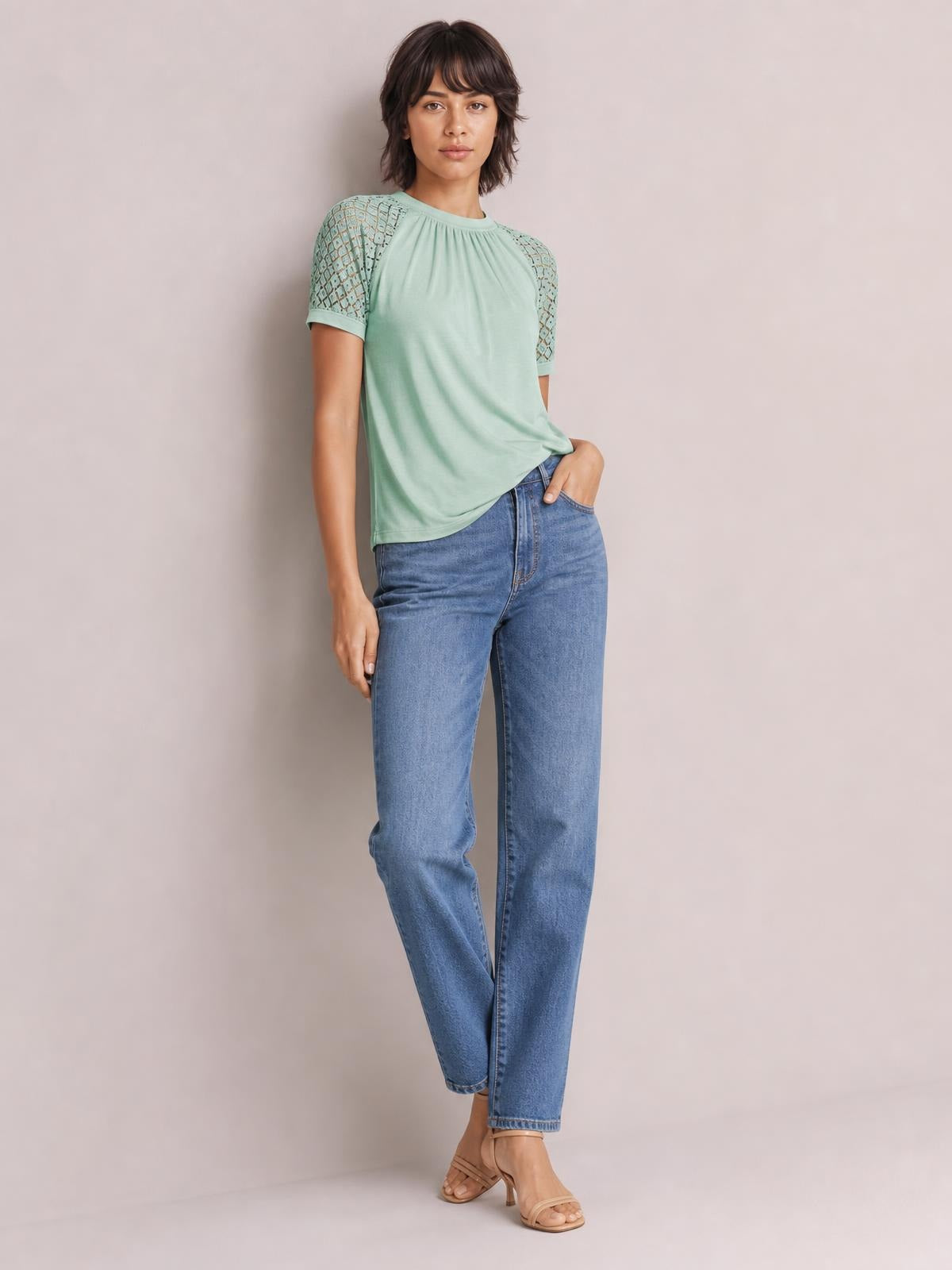 Model poses in a mint green round neck short sleeve T-shirt with gathered neckline, lace-detail shoulders, and a relaxed straight silhouette.