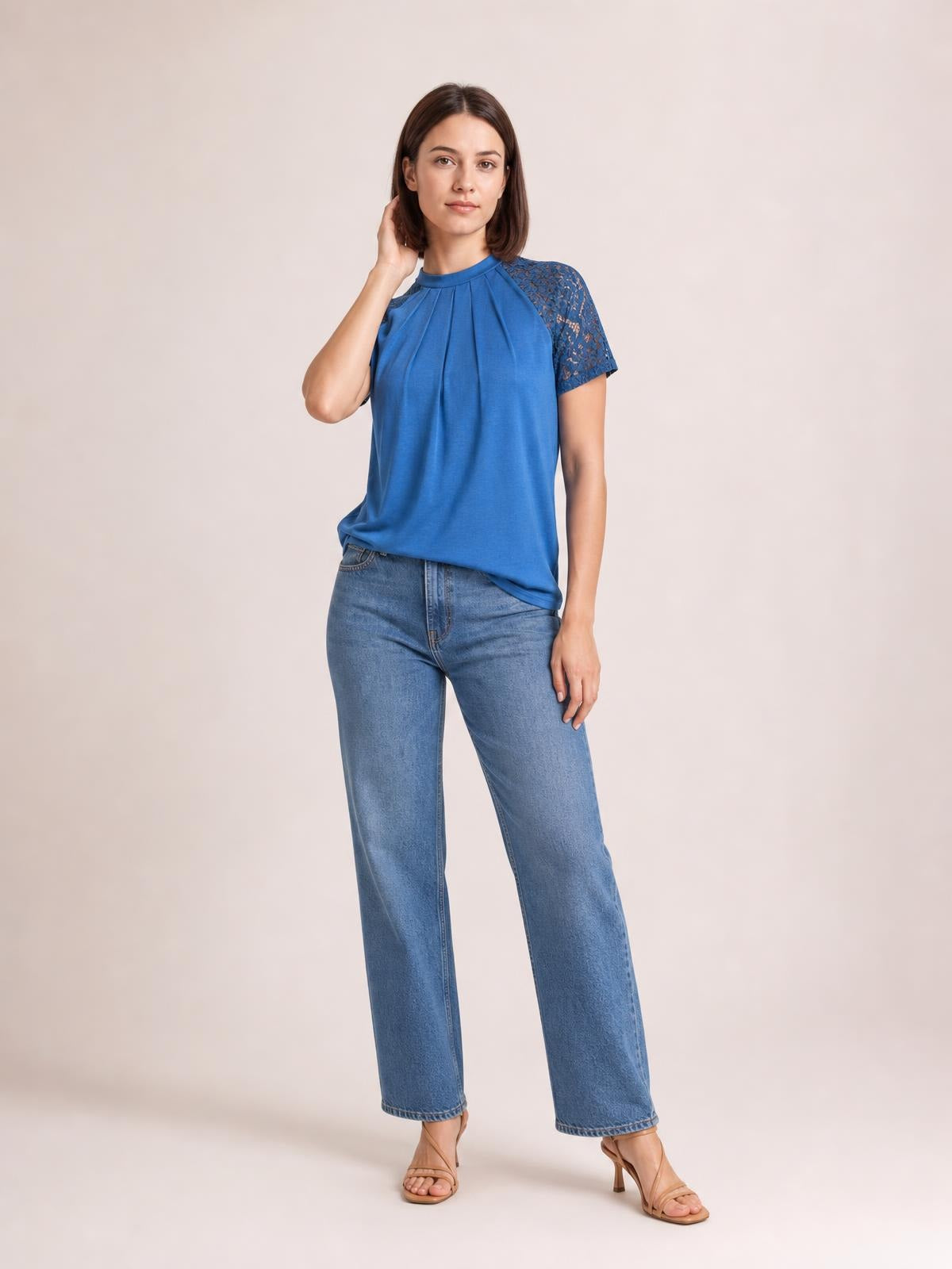 Model wears a blue round neck short sleeve T-shirt with pleated front detailing, lace sleeves, and a relaxed, slightly flowing silhouette.