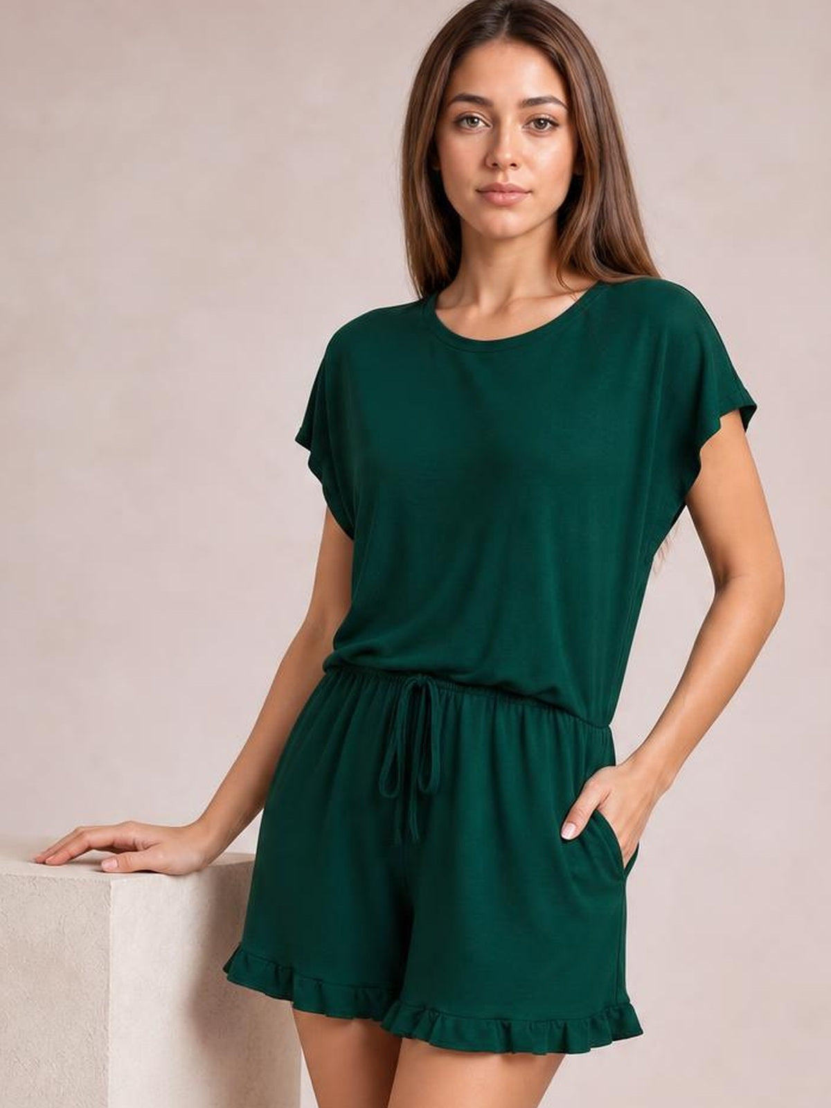 Model wearing a dark green round-neck short-sleeve T-shirt and drawstring shorts lounge set with a relaxed silhouette, side pockets, and frilled shorts hem.