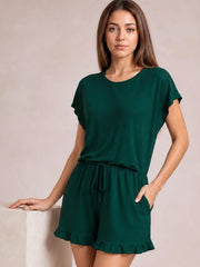 Model wearing a dark green round-neck short-sleeve T-shirt and drawstring shorts lounge set with a relaxed silhouette, side pockets, and frilled shorts hem.