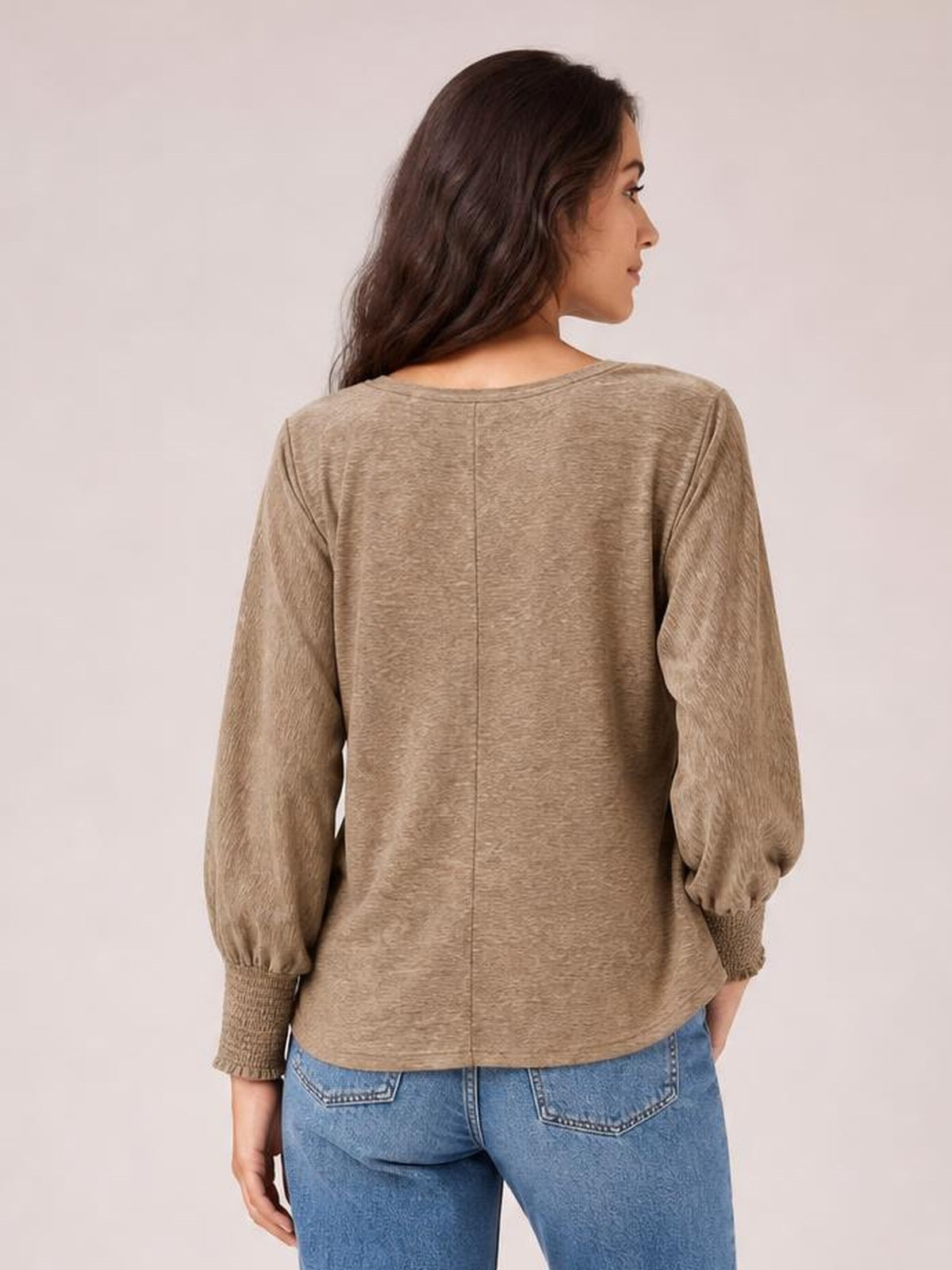 Model shown from behind wears a taupe round-neck T-shirt with voluminous lantern sleeves, smocked cuffs, a relaxed silhouette, and center-back seam.