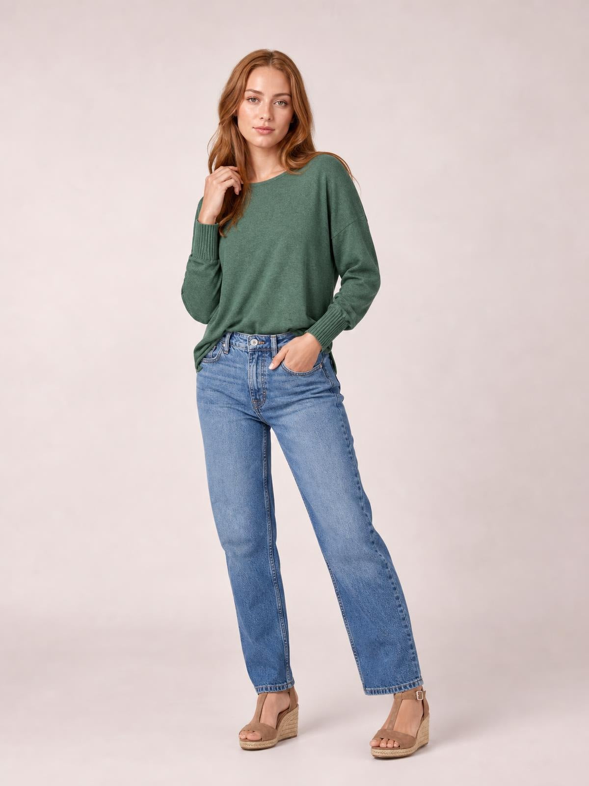 A model poses in a soft green round-neck t-shirt with a relaxed silhouette, long lantern sleeves, and fitted ribbed cuffs.