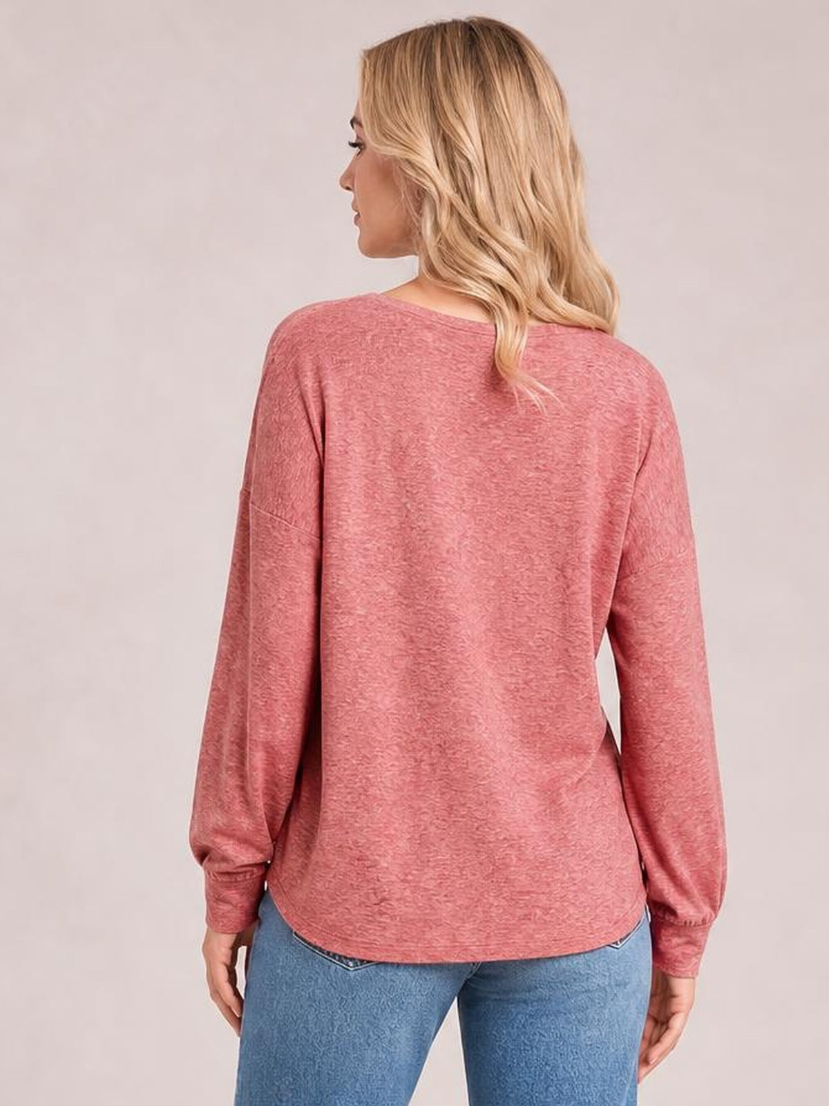 A model viewed from behind wears a rose pink round neck T-shirt with a relaxed silhouette, long lantern sleeves, gathered cuffs, and subtle smocked texture.