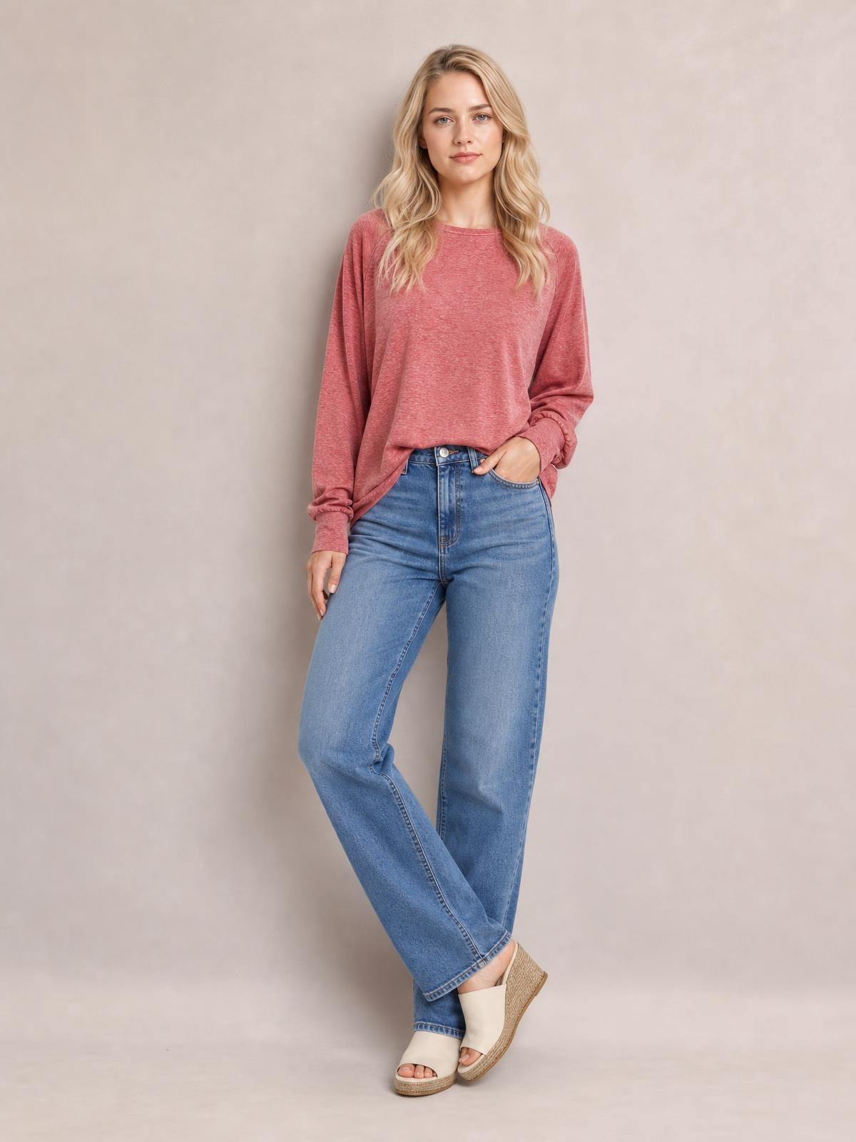 Model poses with one hand in her jeans pocket wearing a dusty rose round-neck t-shirt with relaxed lantern sleeves and gathered cuffs.