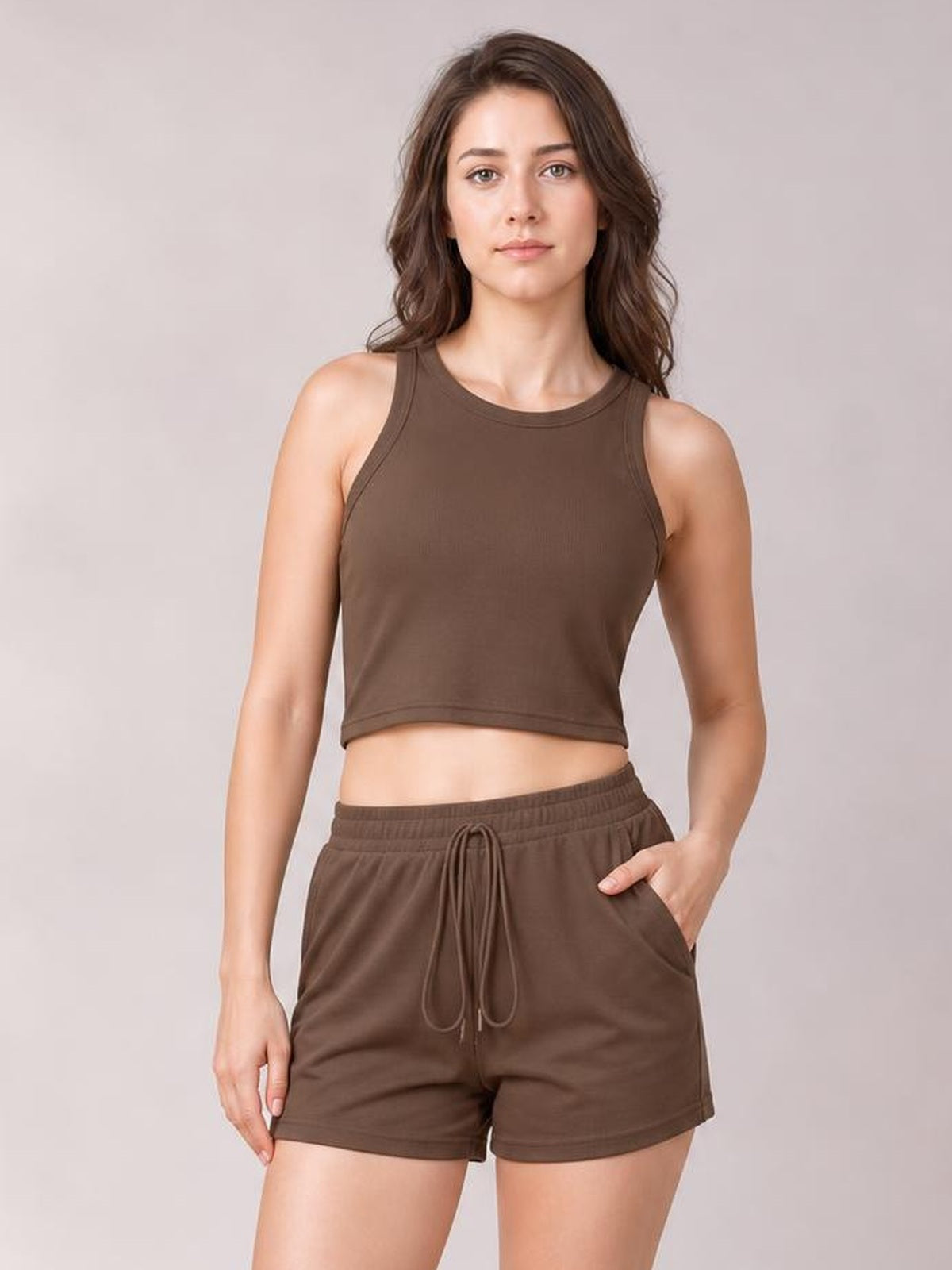 Model poses in a brown round neck tank and matching drawstring shorts set with a cropped silhouette, elastic waistband, and side pockets.