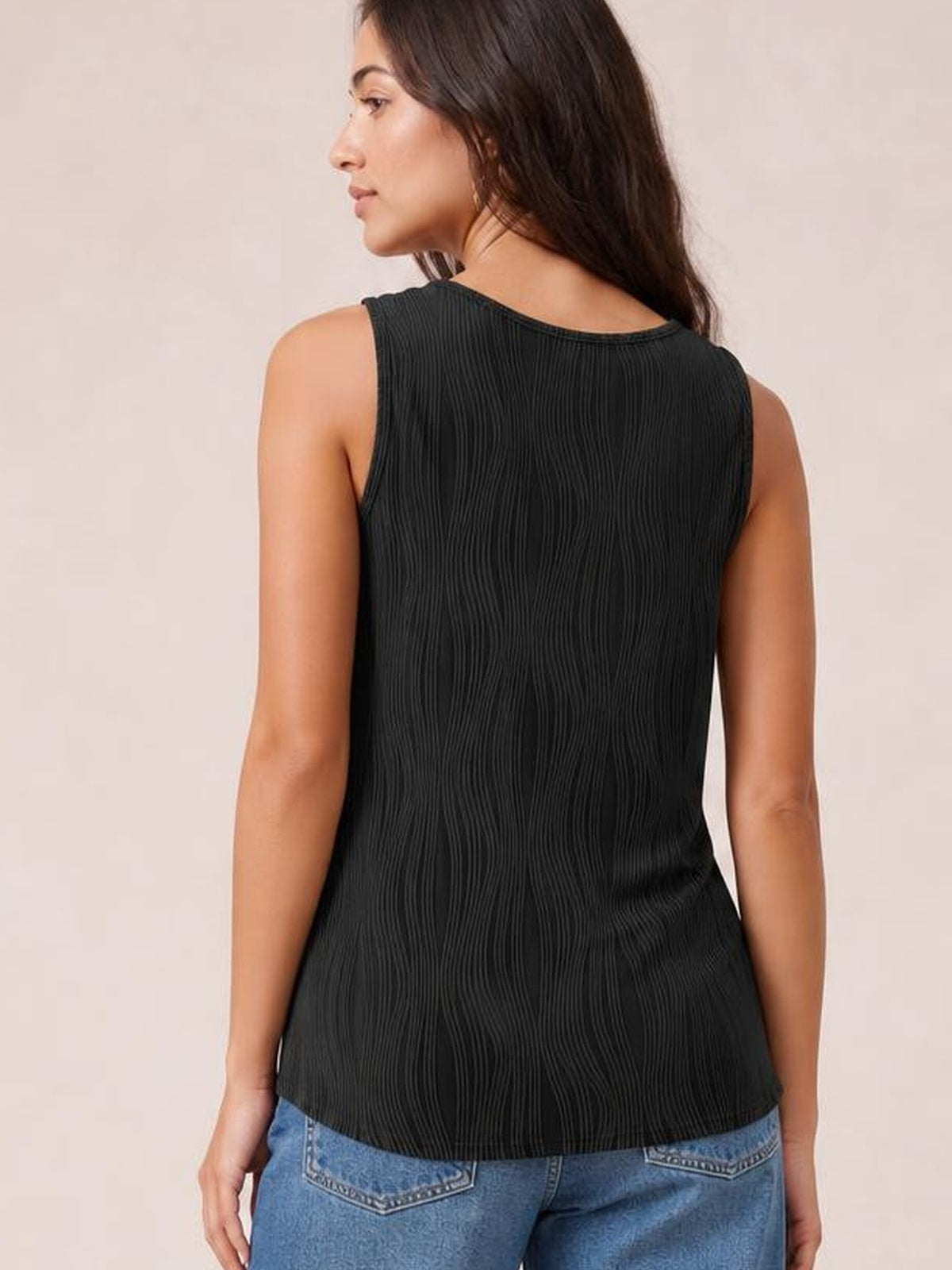 Model shown from behind in a black round-neck wide-strap tank with a relaxed straight silhouette, textured vertical finish, and curved hem.