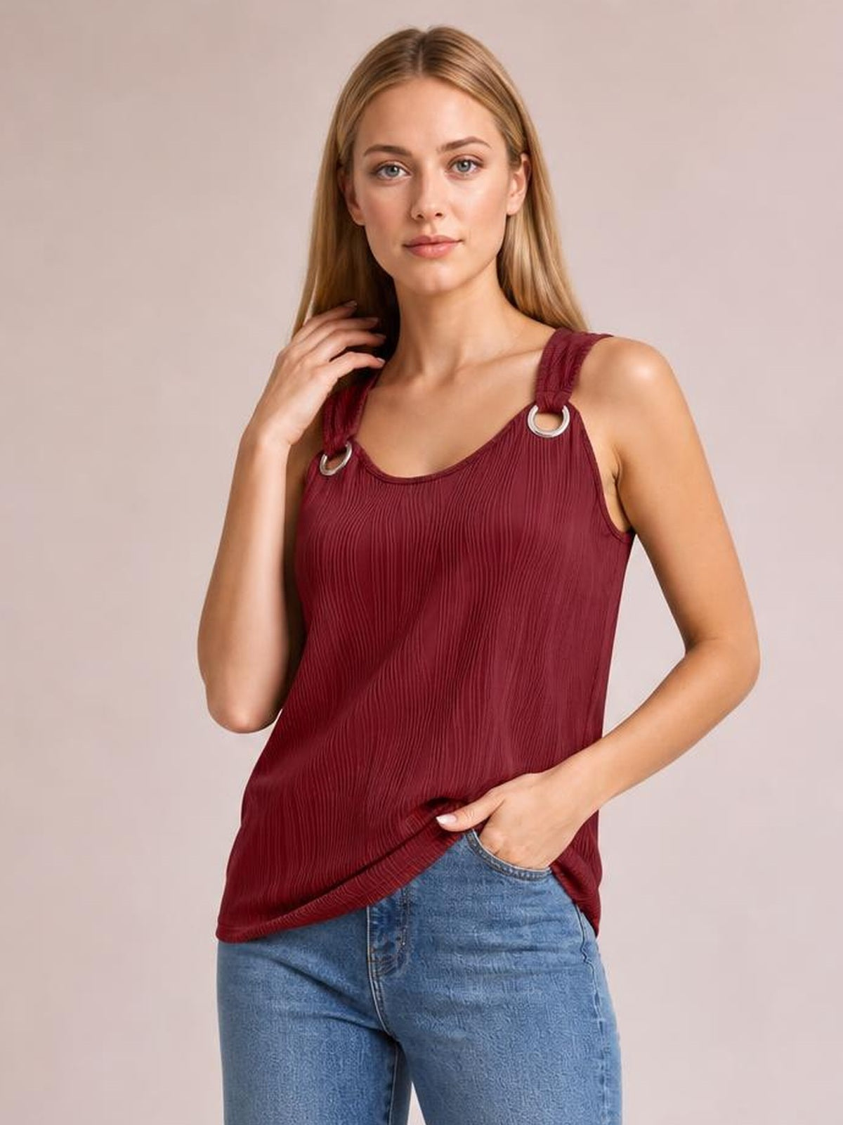 A woman models a burgundy round-neck wide-strap tank with a relaxed straight silhouette, vertical texture, and ring-accented shoulder straps, touching her hair.