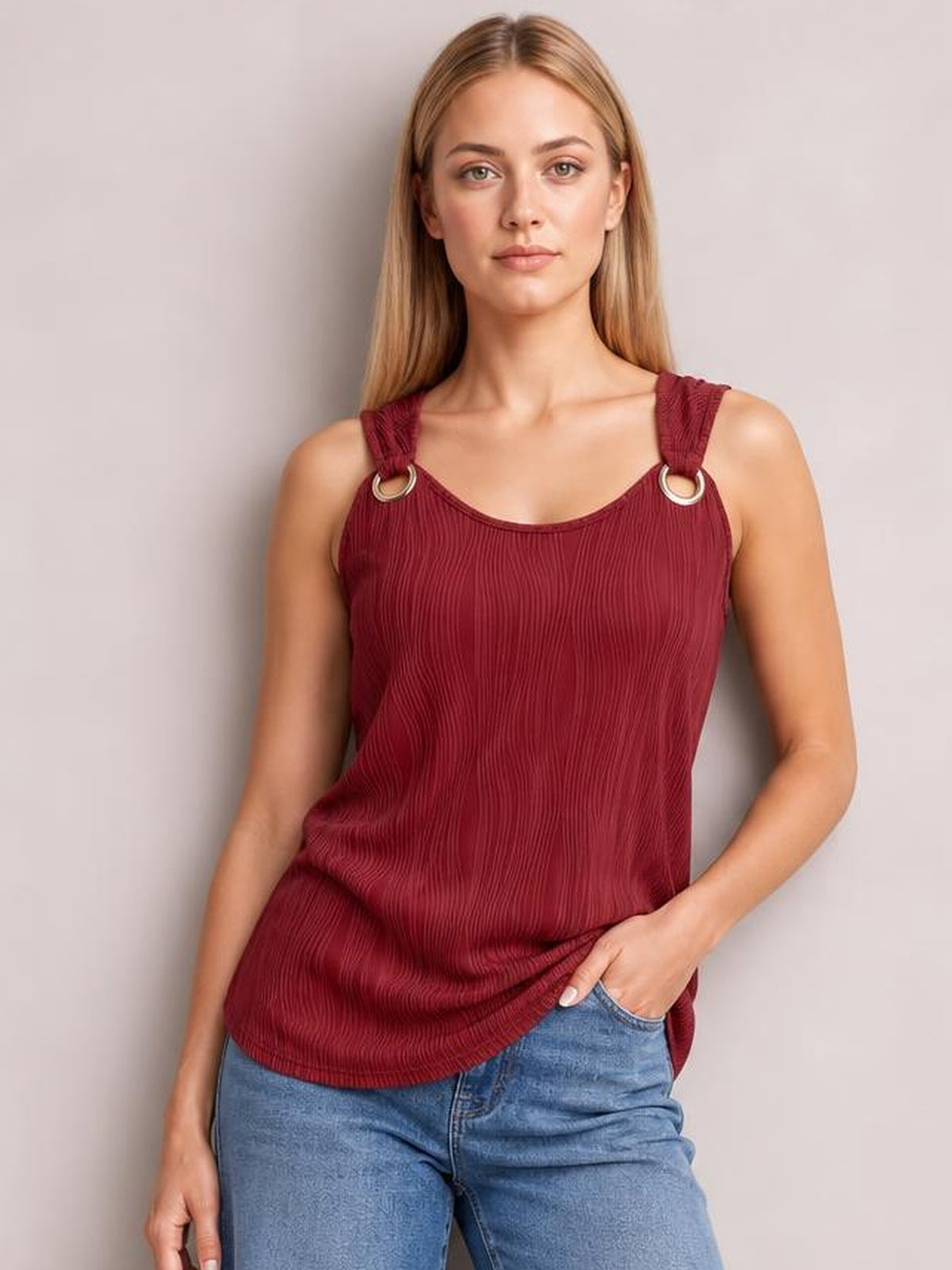 Model wearing a burgundy round neck wide strap tank with a relaxed, slightly loose silhouette, textured vertical pleats, and ring-accented shoulder straps.
