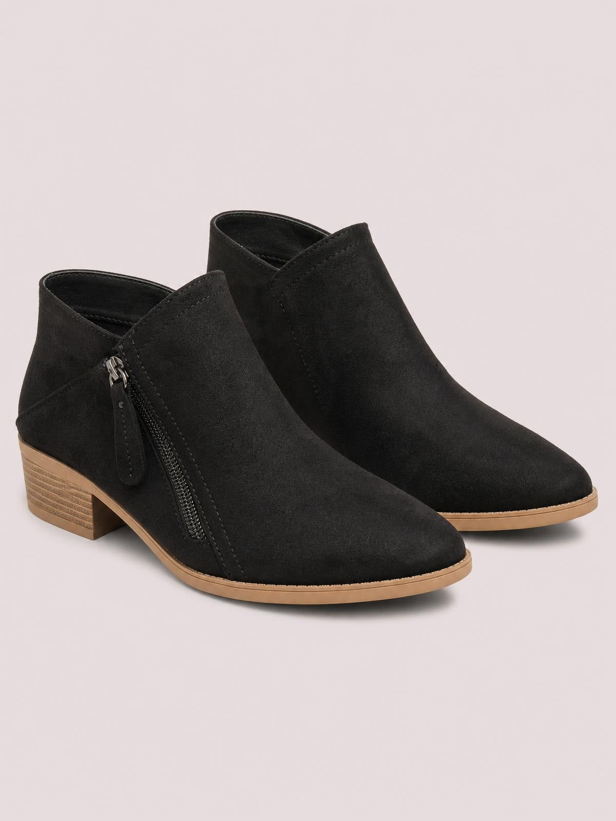 Black PU leather ankle boots feature rounded toes, low block heels, side zippers, stitched panels, and contrasting tan rubber soles.