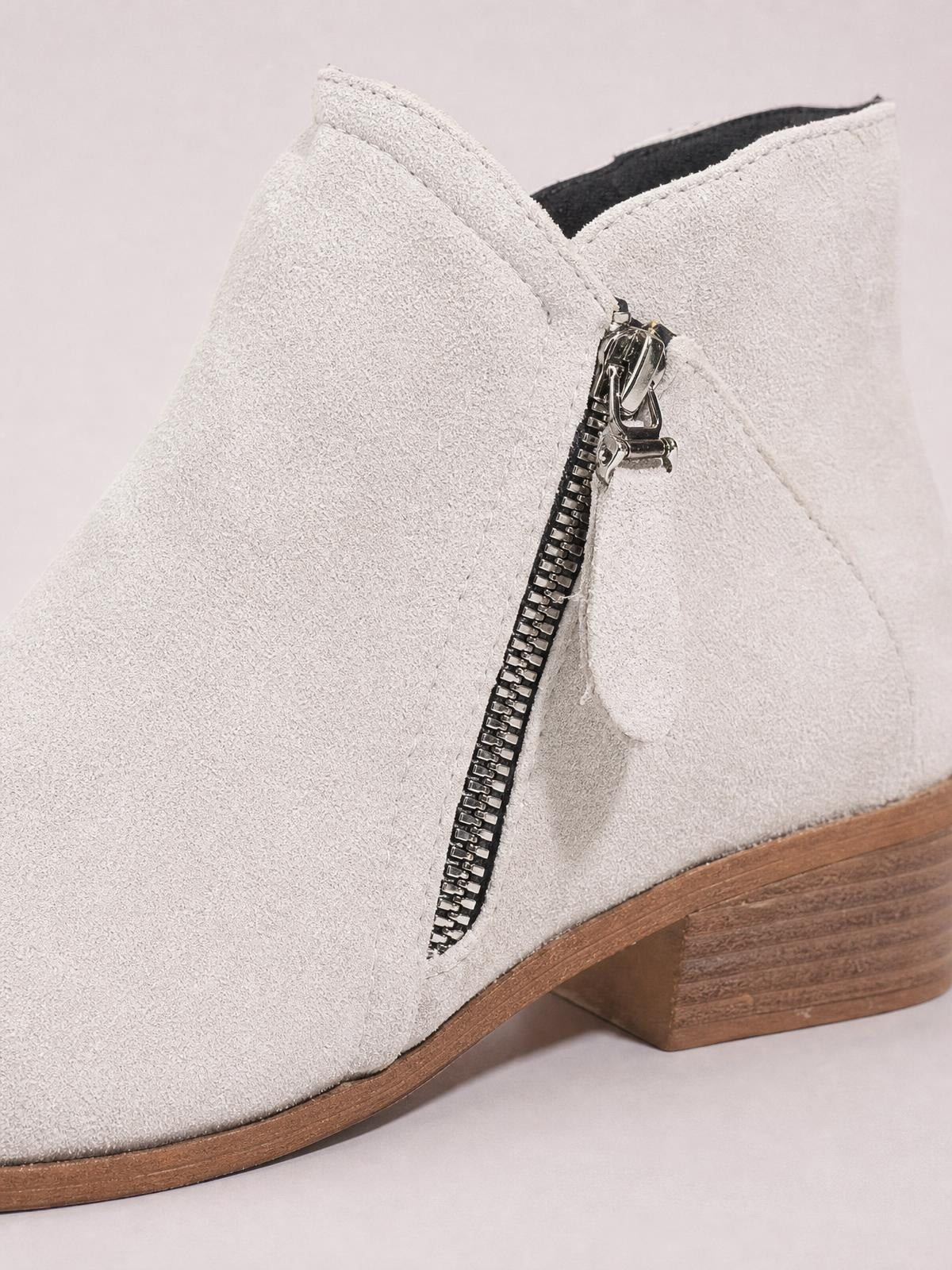 Light beige round toe block heel boots in PU leather feature a low stacked heel, side zipper, stitched panels, and a sturdy rubber sole.
