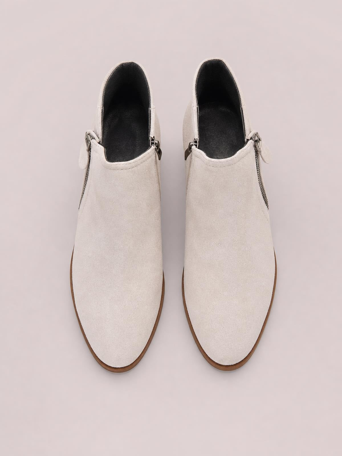 Cream PU leather ankle boots with round toes, low block heels, dark lining, and side zippers create a streamlined silhouette.