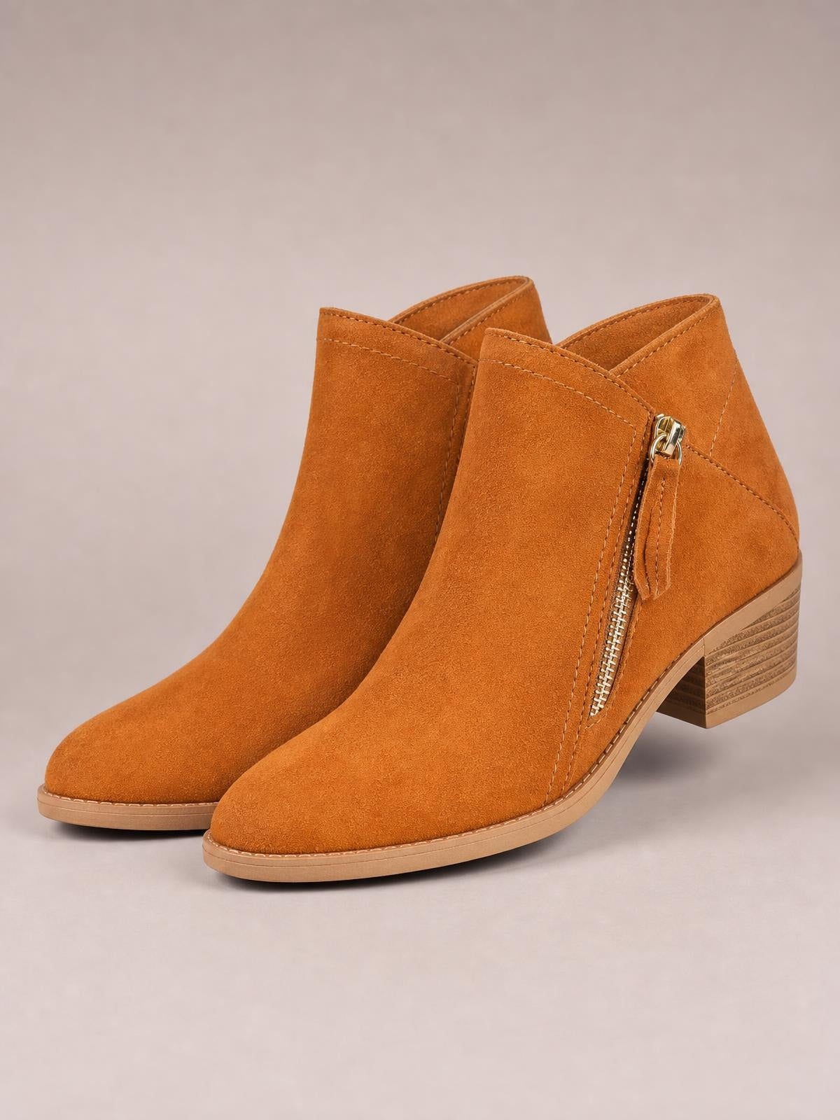 Rust-orange PU leather round-toe ankle boots feature side zippers, stitched panel construction, rubber soles, and low stacked block heels.