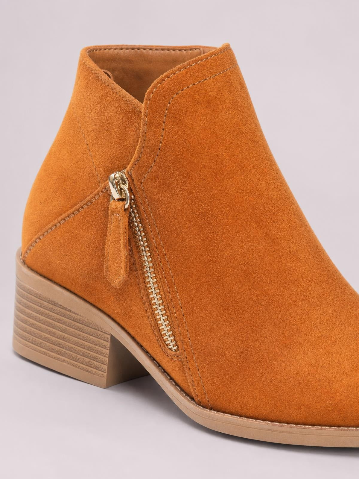 Tan PU leather ankle boots feature round toes, low block heels, side zippers, contrast stitching, and textured rubber soles.
