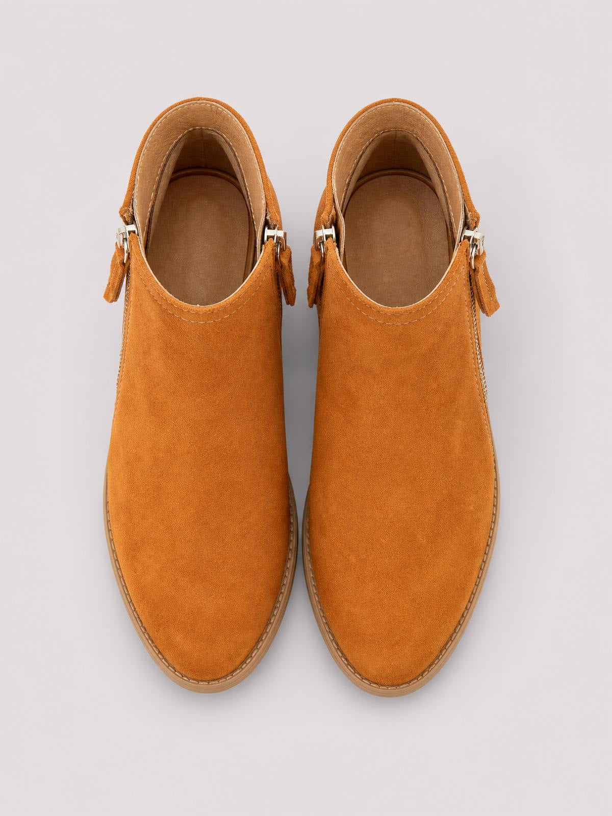 Top-down view of tan PU leather ankle boots with round toes, low block heels, side buckle straps, stitched edges, and rubber soles.