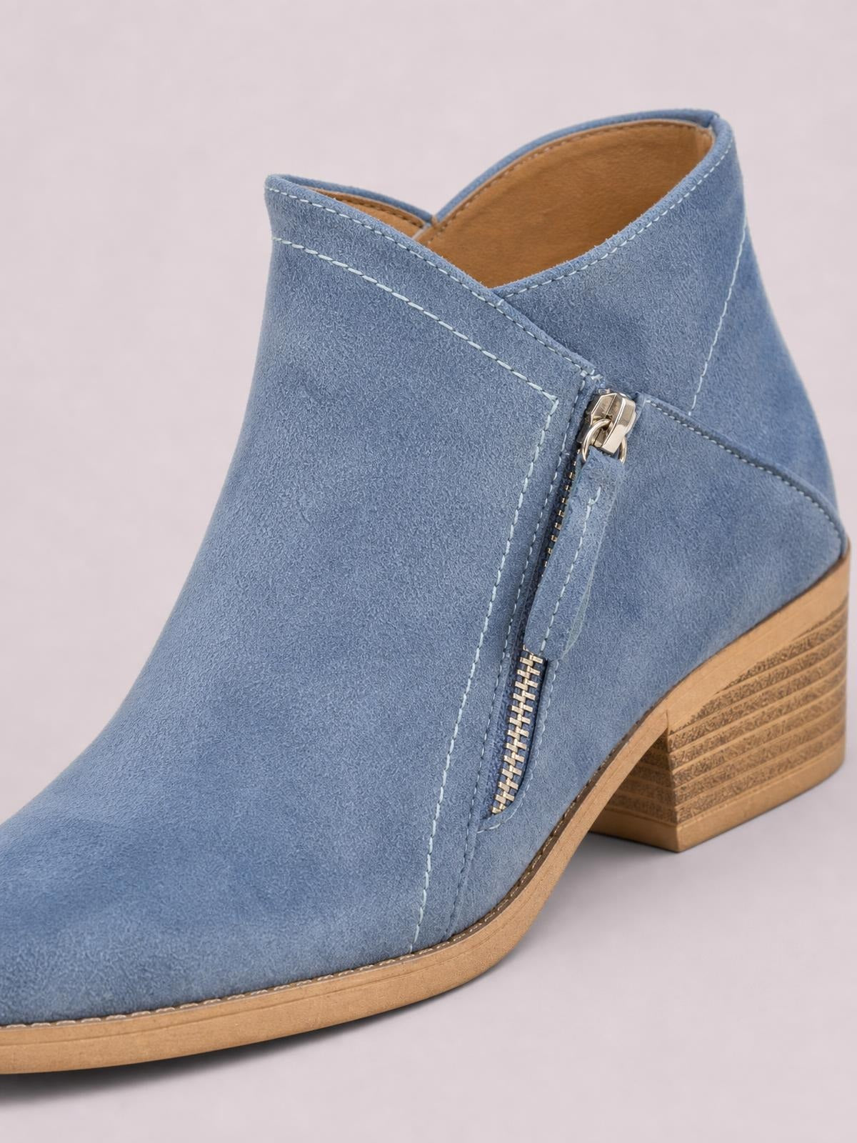 Blue PU leather ankle boot with a round toe, low block heel, side zipper, contrast stitching, and a layered rubber sole.