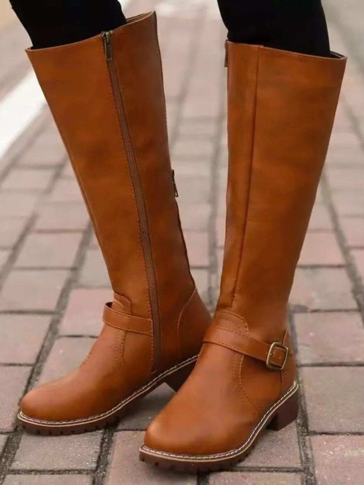 Tan PU leather round toe block heel boots with tall shafts, side zippers, ankle straps, buckles, and low heels worn with black leggings.