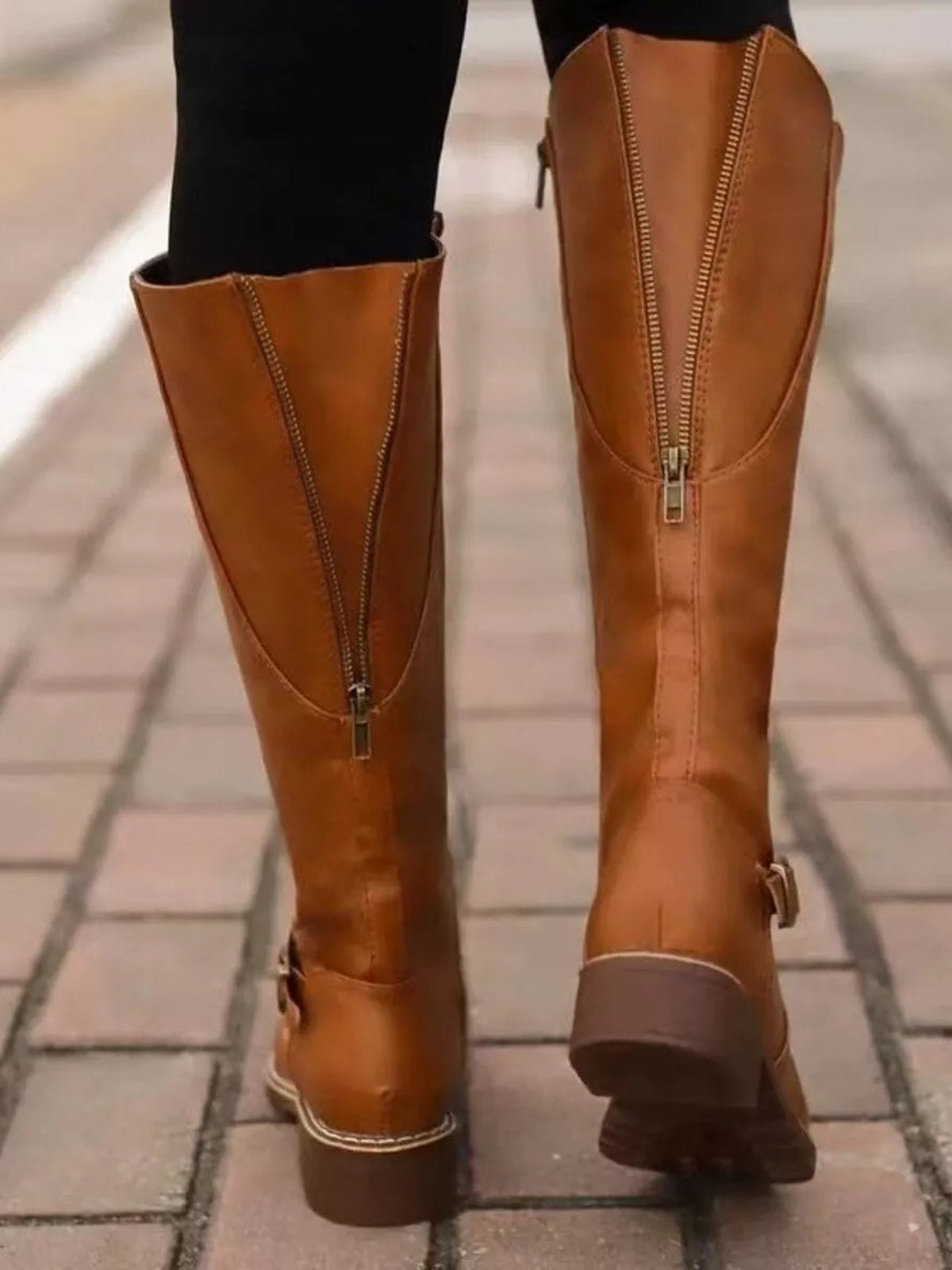 A model wears tan PU leather round-toe boots with tall shafts, full-length front zippers, side buckles, and sturdy low block heels.