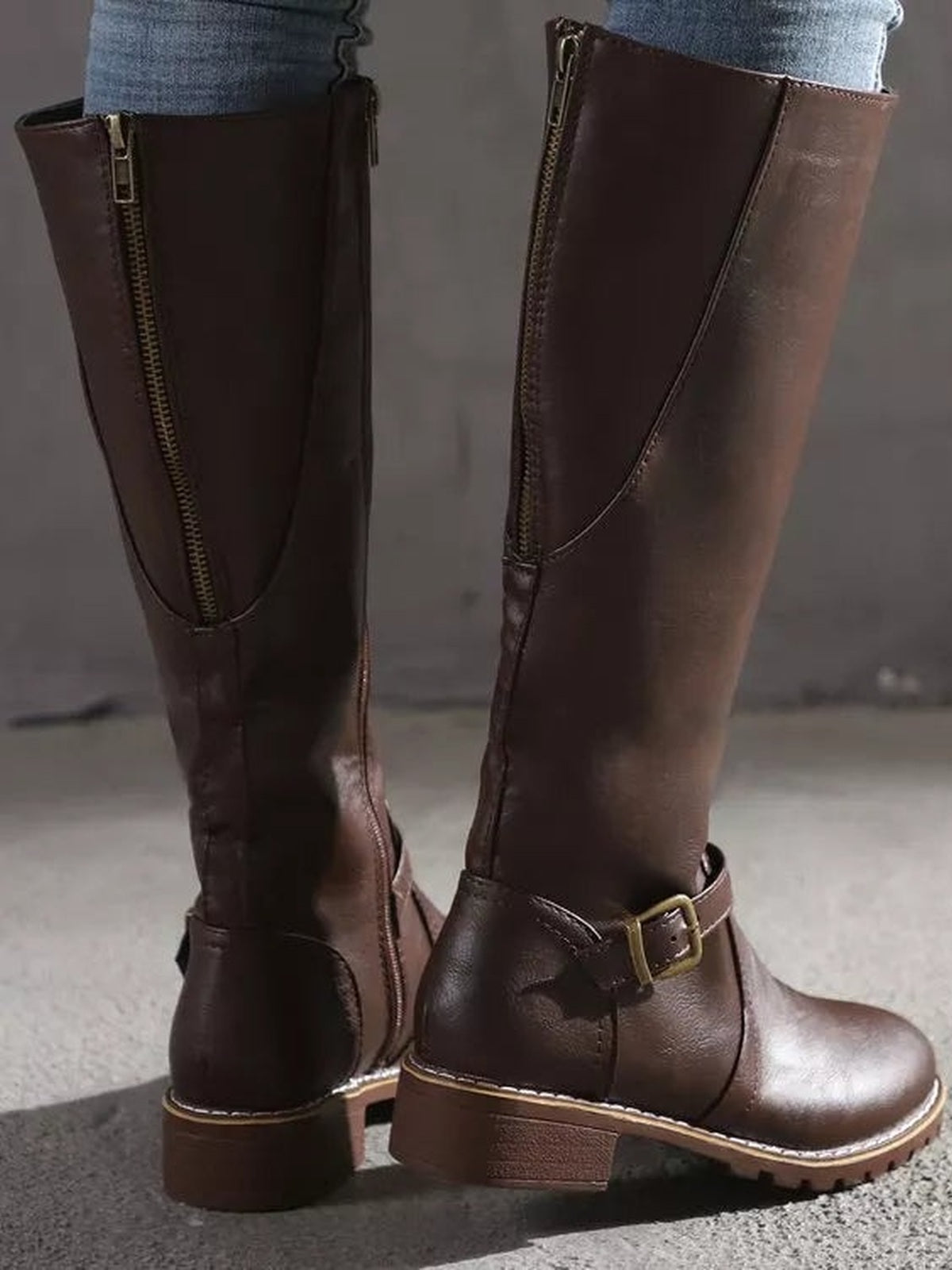 Brown PU leather round-toe block-heel boots feature tall shafts, side zippers, ankle buckle straps, stitched panels, and sturdy rubber soles.