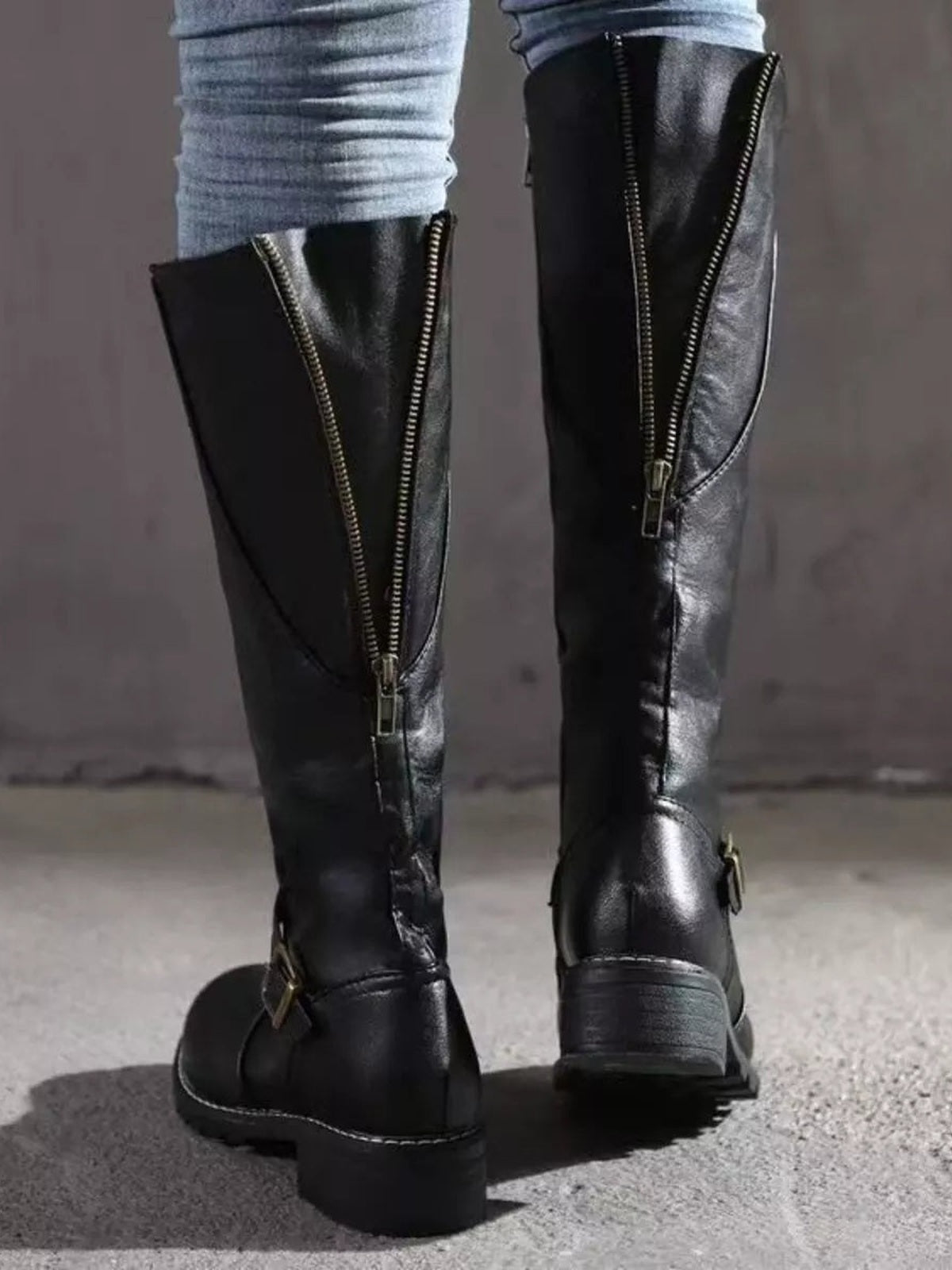 Black PU leather round toe block heel boots with tall shafts, front zippers, side buckles, and low chunky heels modeled with fitted jeans.