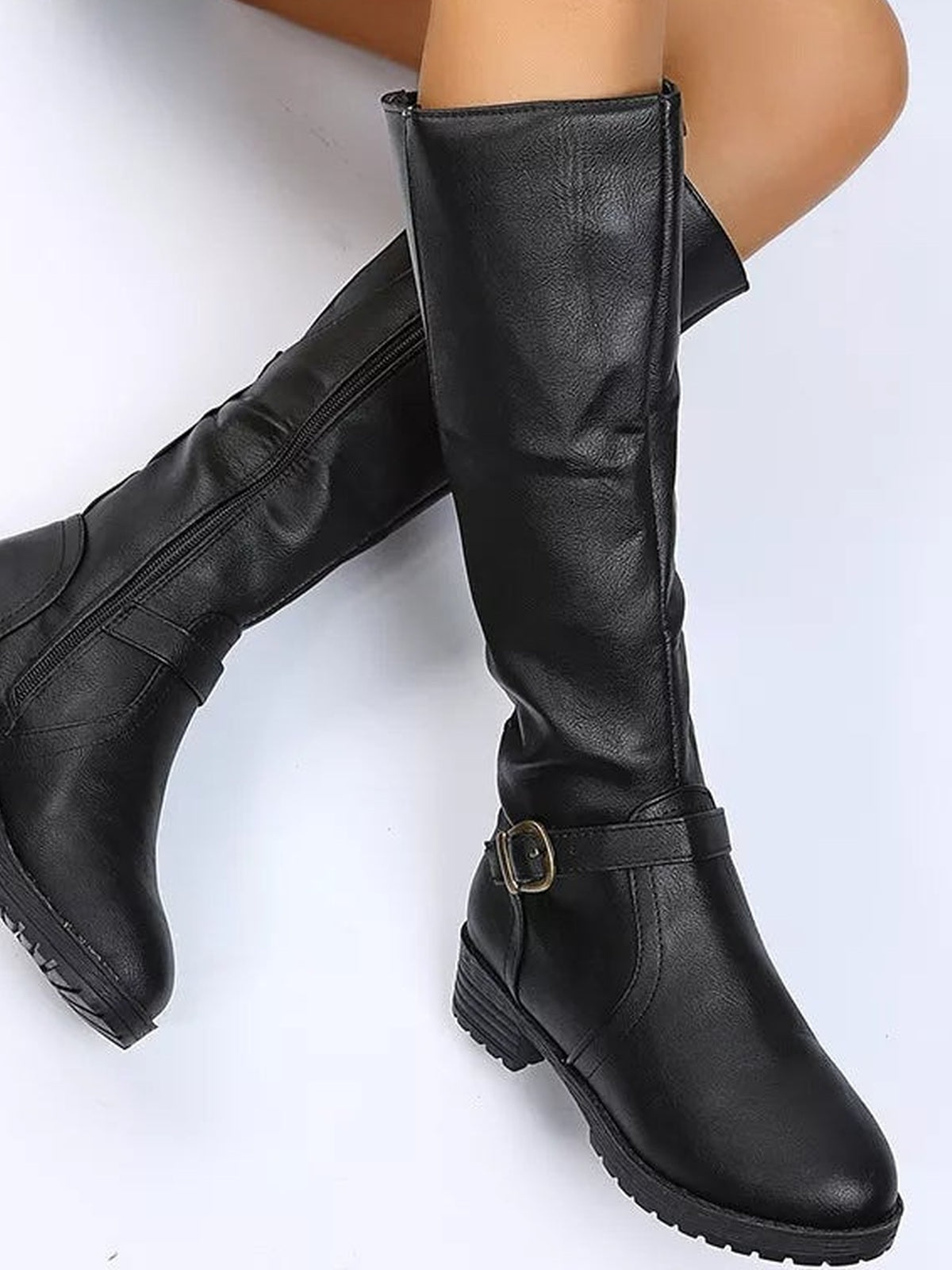 Model wears black PU leather round toe block heel boots with low heels, tall shafts, side zippers, and buckled ankle straps.
