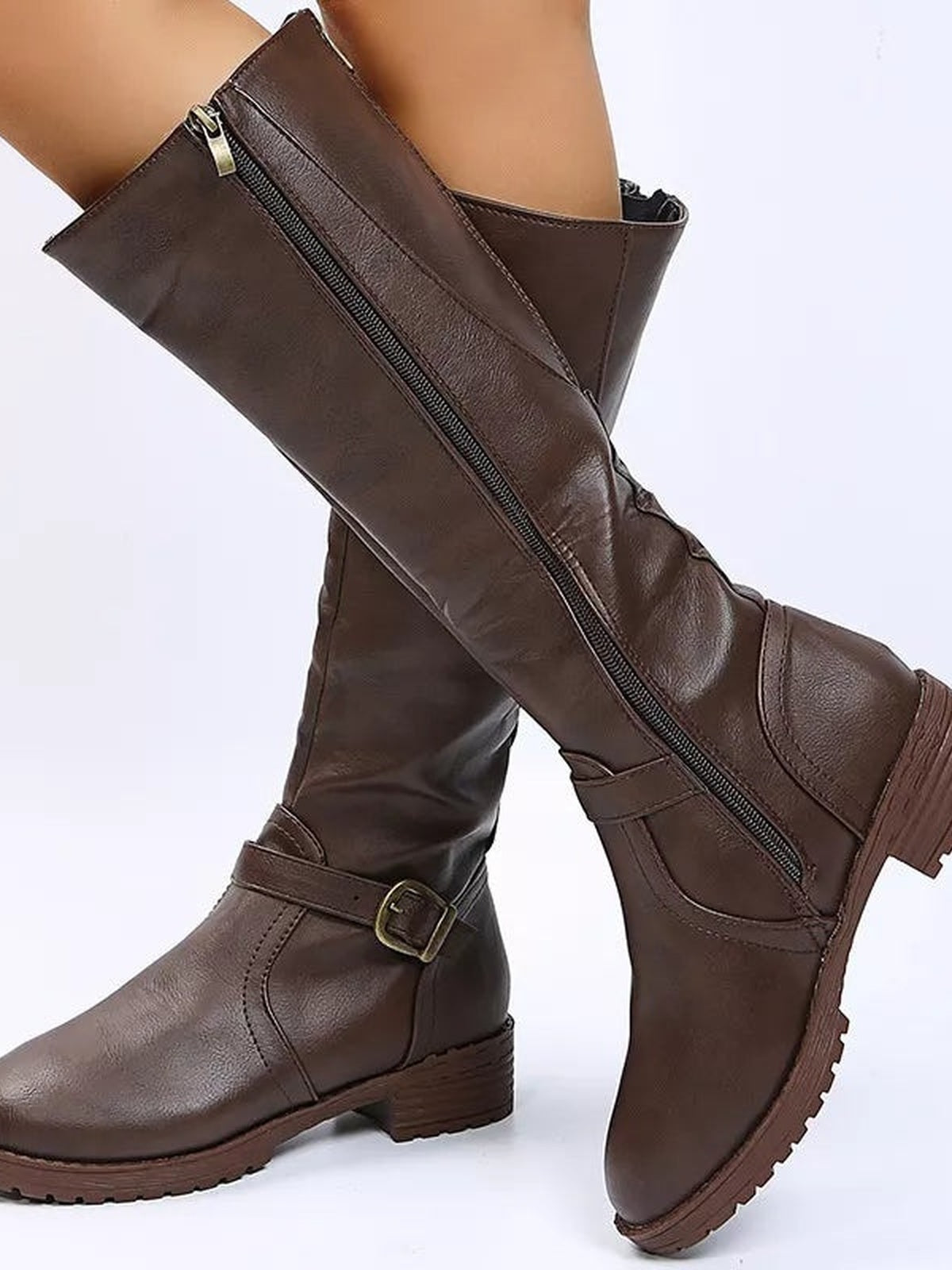 A model wears brown PU leather round-toe block heel boots with tall shafts, side zippers, buckle straps, low heels, and lugged rubber soles.