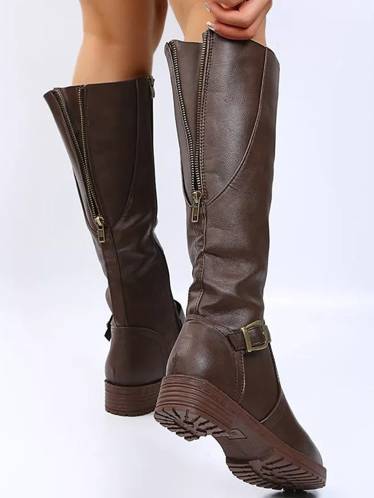 A model displays brown PU leather round toe block heel boots with tall shafts, side zippers, buckle straps, low heels, and textured rubber soles.