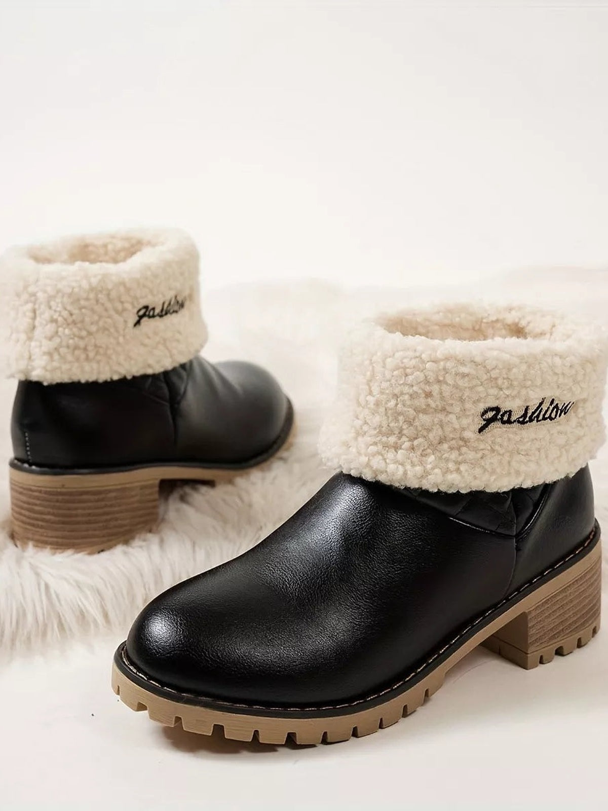 Black round-toe block-heel boots in PU leather feature cream fluff cuffs, low wood-look heels, and chunky rubber lug soles.