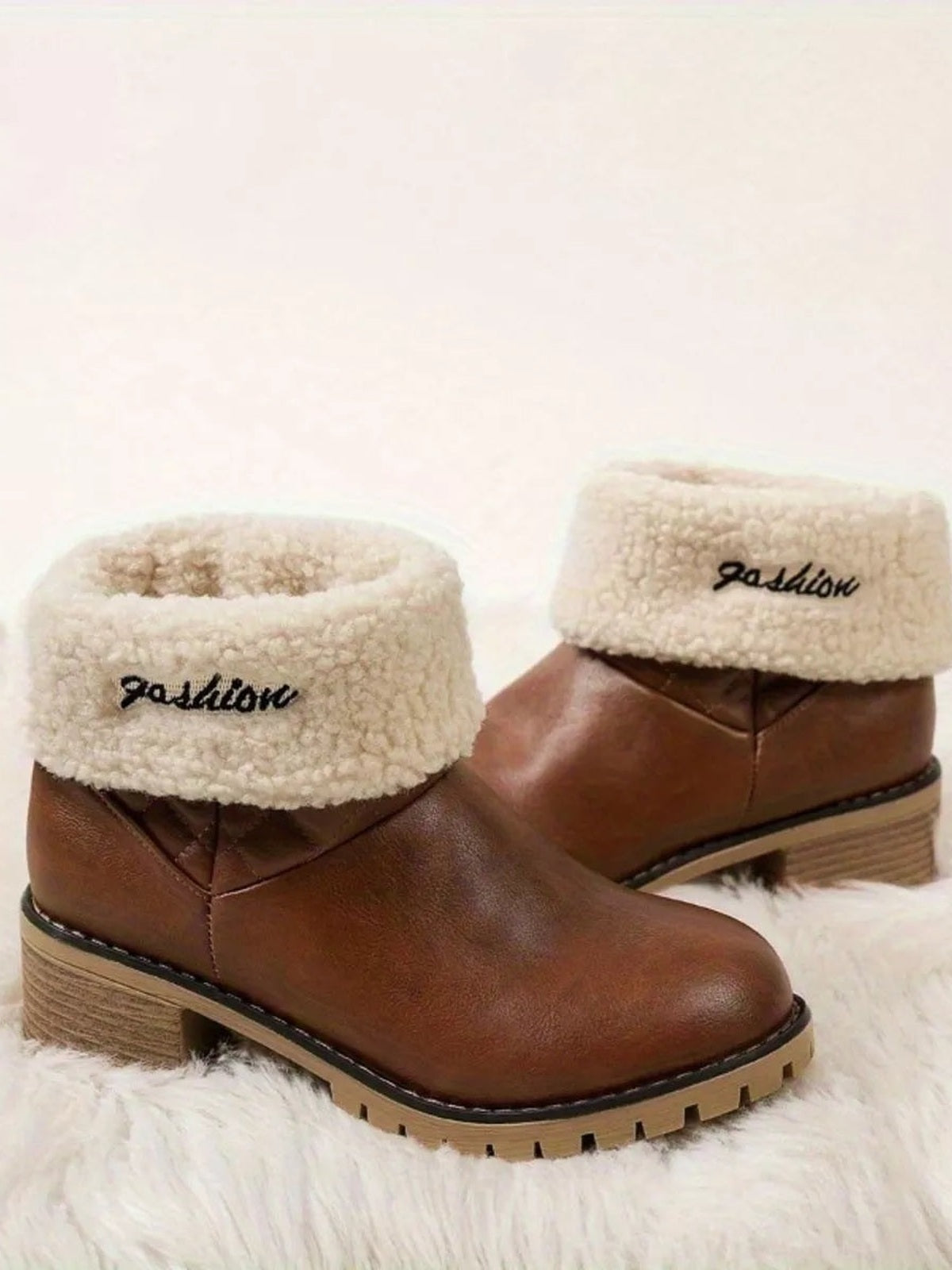 Brown PU leather round toe block heel boots with cream fluffy cuffs, low stacked heels, stitched panels, and rugged rubber lug soles.