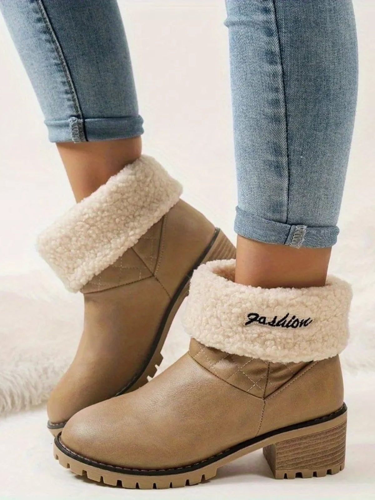 Model wears tan round-toe block-heel boots with soft cream fluff cuffs, stitched PU leather uppers, and chunky rubber lug soles.
