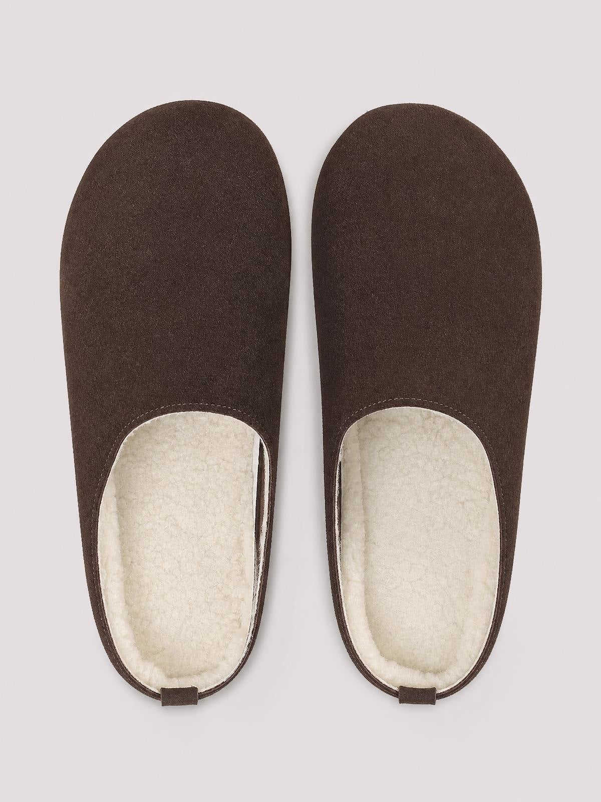 Pair of dark brown suede round-toe flat slippers with open backs, cream plush lining, and a simple slip-on silhouette.
