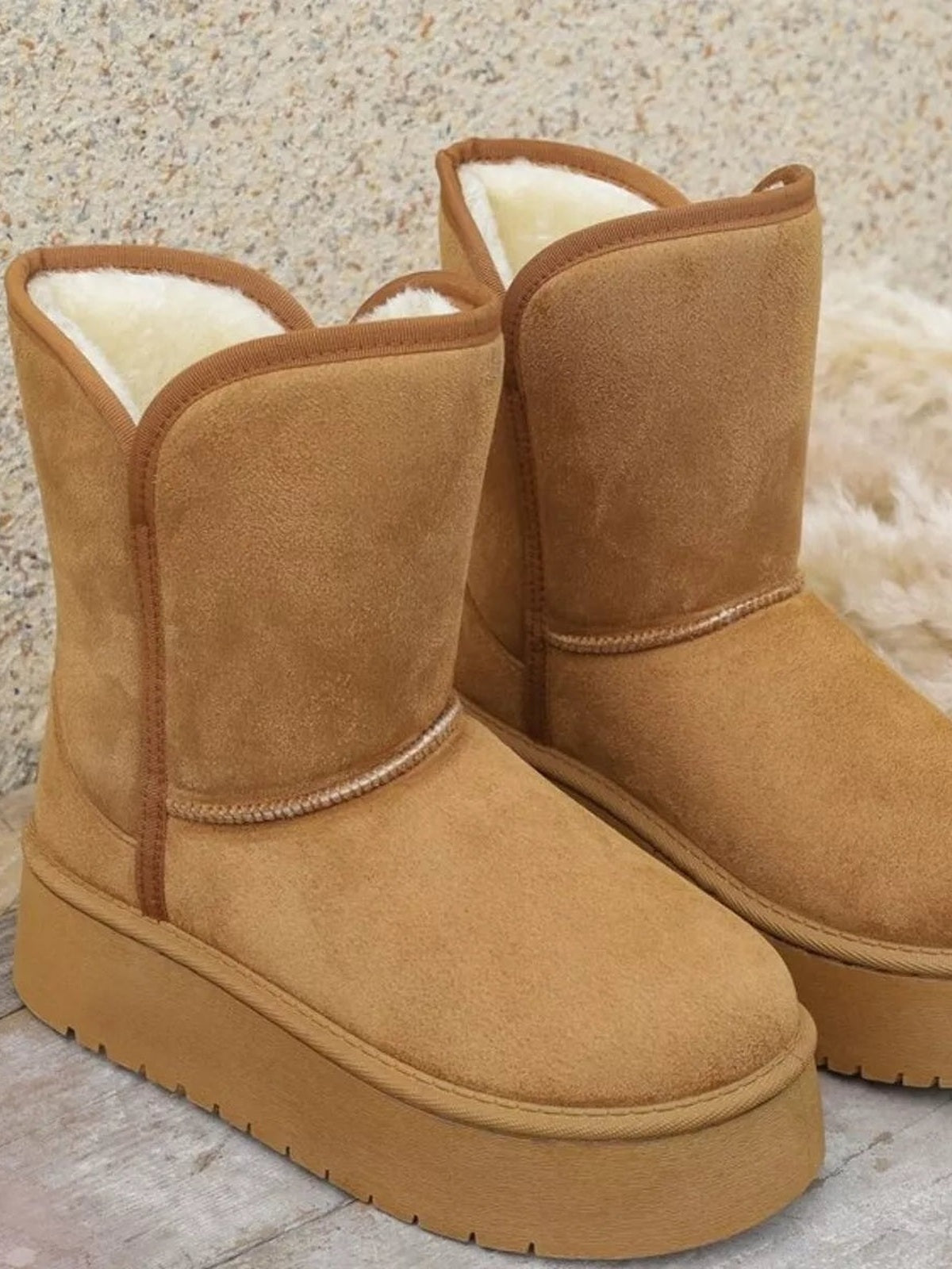 Tan round toe platform boots in PU leather with plush lining, tall shafts, stitched panel construction, and thick rubber soles.