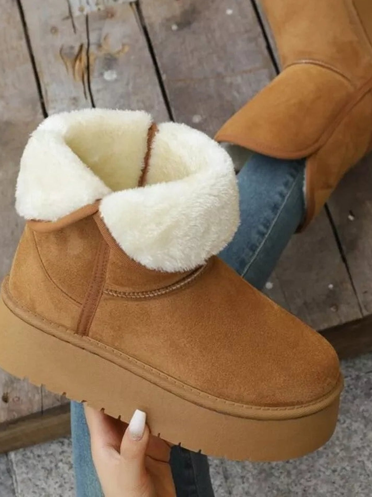 Tan round-toe platform boots feature plush white fluff lining, stitched panel construction, a thick rubber lug sole, and a flat platform silhouette.
