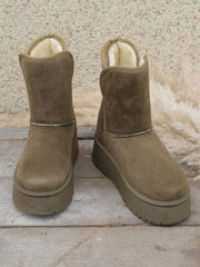 Taupe round-toe platform boots feature a short shaft, plush lining, stitched panels, and thick flat rubber soles for a sturdy silhouette.