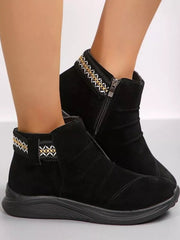 Model wears black round toe platform boots with suede-like uppers, side zippers, decorative patterned trim, and thick rubber soles.