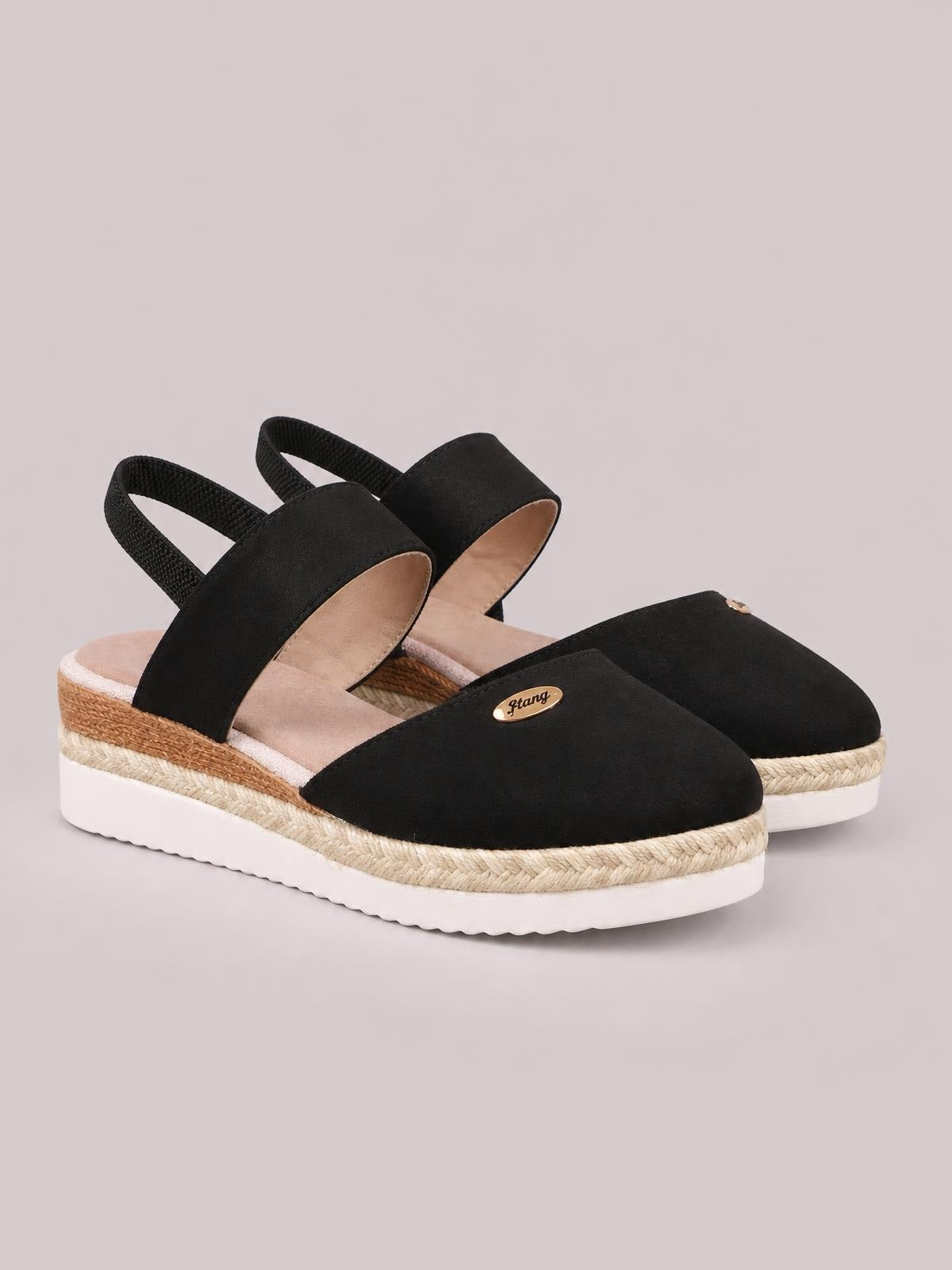 Black canvas round-toe wedge sandals feature broad front straps, elastic heel loops, braided espadrille-style midsoles, and white rubber platform soles.