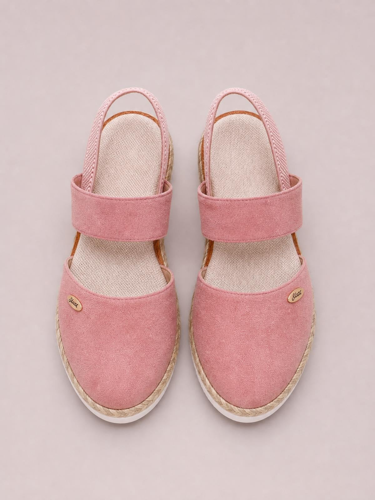 Pink round toe wedge sandals feature wide canvas straps, textured insoles, rope-wrapped mid heels, and white rubber outsoles.