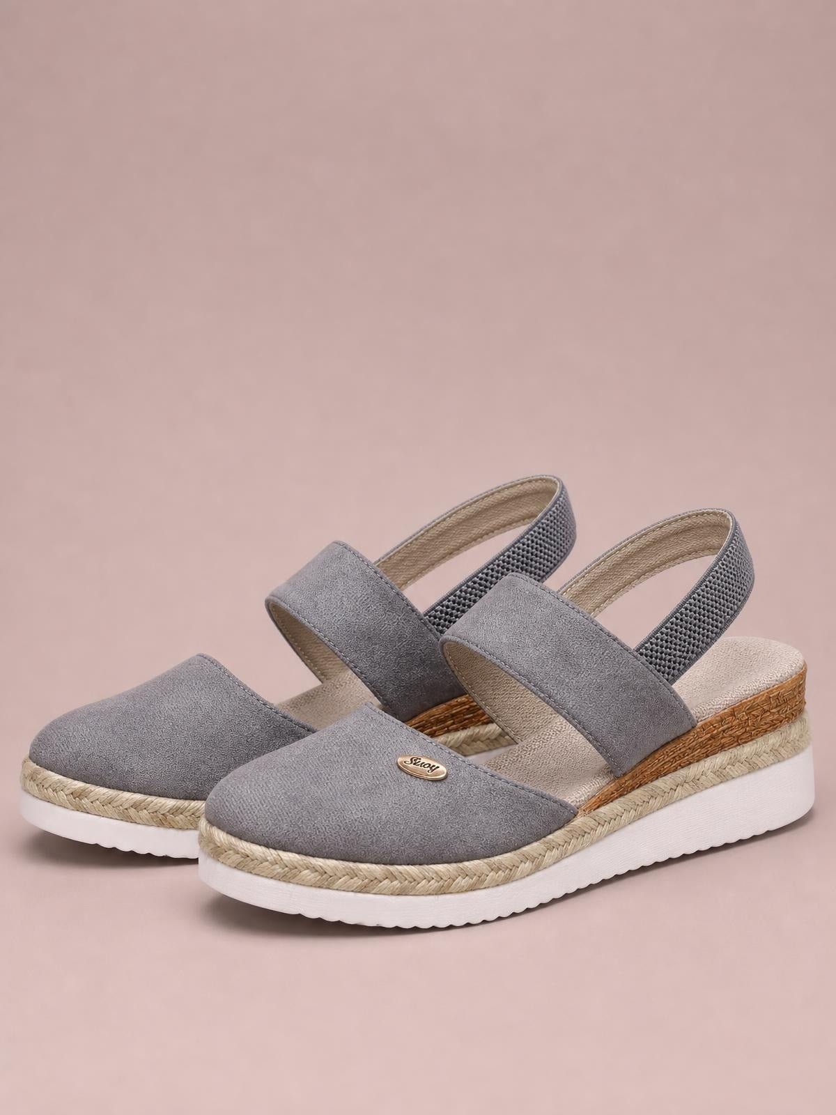 Gray round toe wedge sandals feature broad canvas straps, slingback heels, woven espadrille-style midsoles, and white rubber soles.