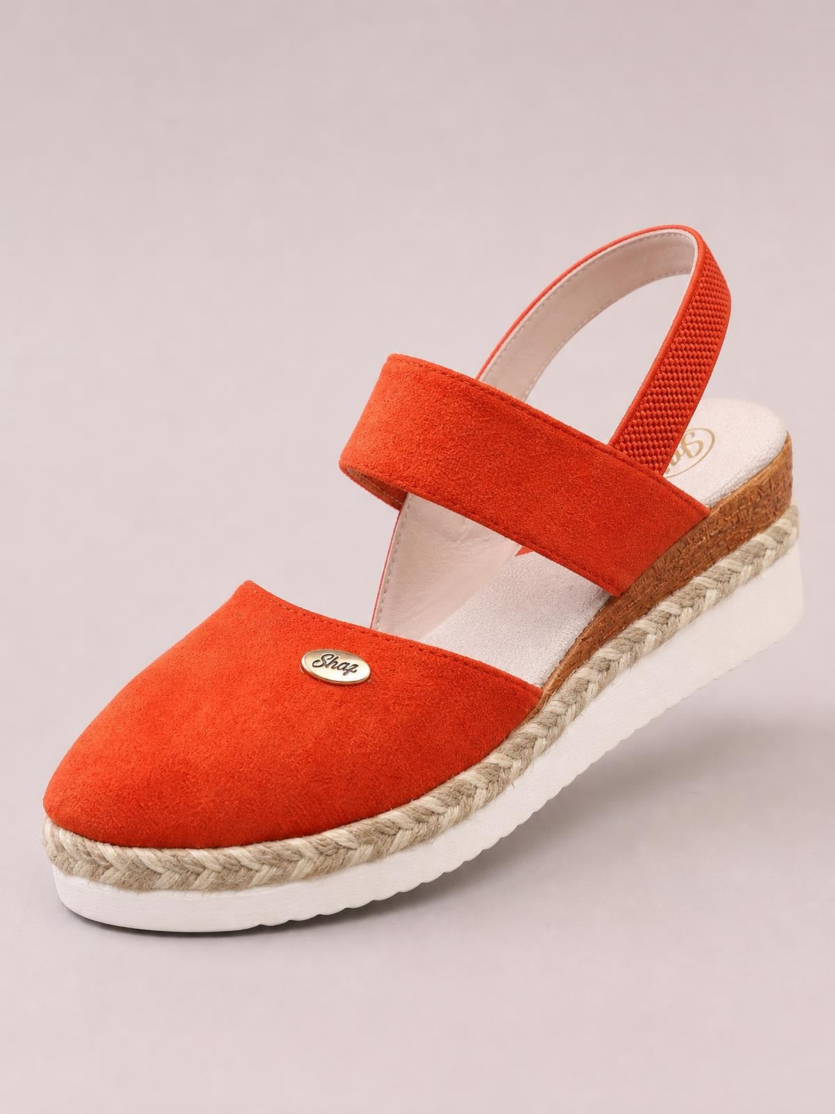 Bright orange round-toe wedge sandals feature broad crossover straps, an adjustable slingback, rope-wrapped midsole, and a white rubber platform sole.