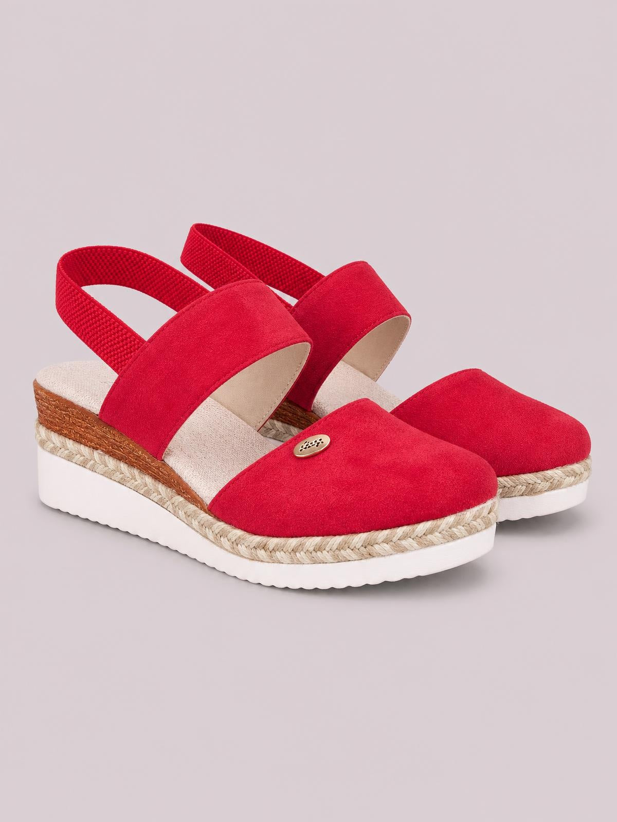 Red round-toe wedge sandals feature wide crossover straps, slingback bands, woven espadrille trim, and a white rubber platform sole with a mid-height wedge heel.