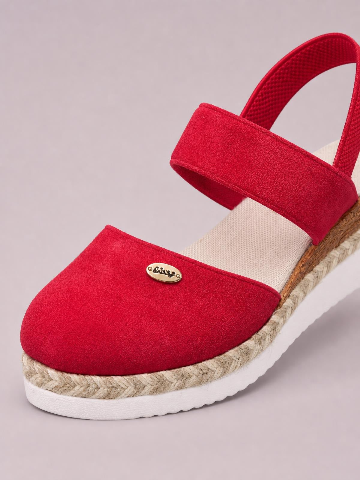 Bright red round-toe wedge sandals feature textured canvas straps, a gold-tone accent, and a braided espadrille platform with a white rubber sole.